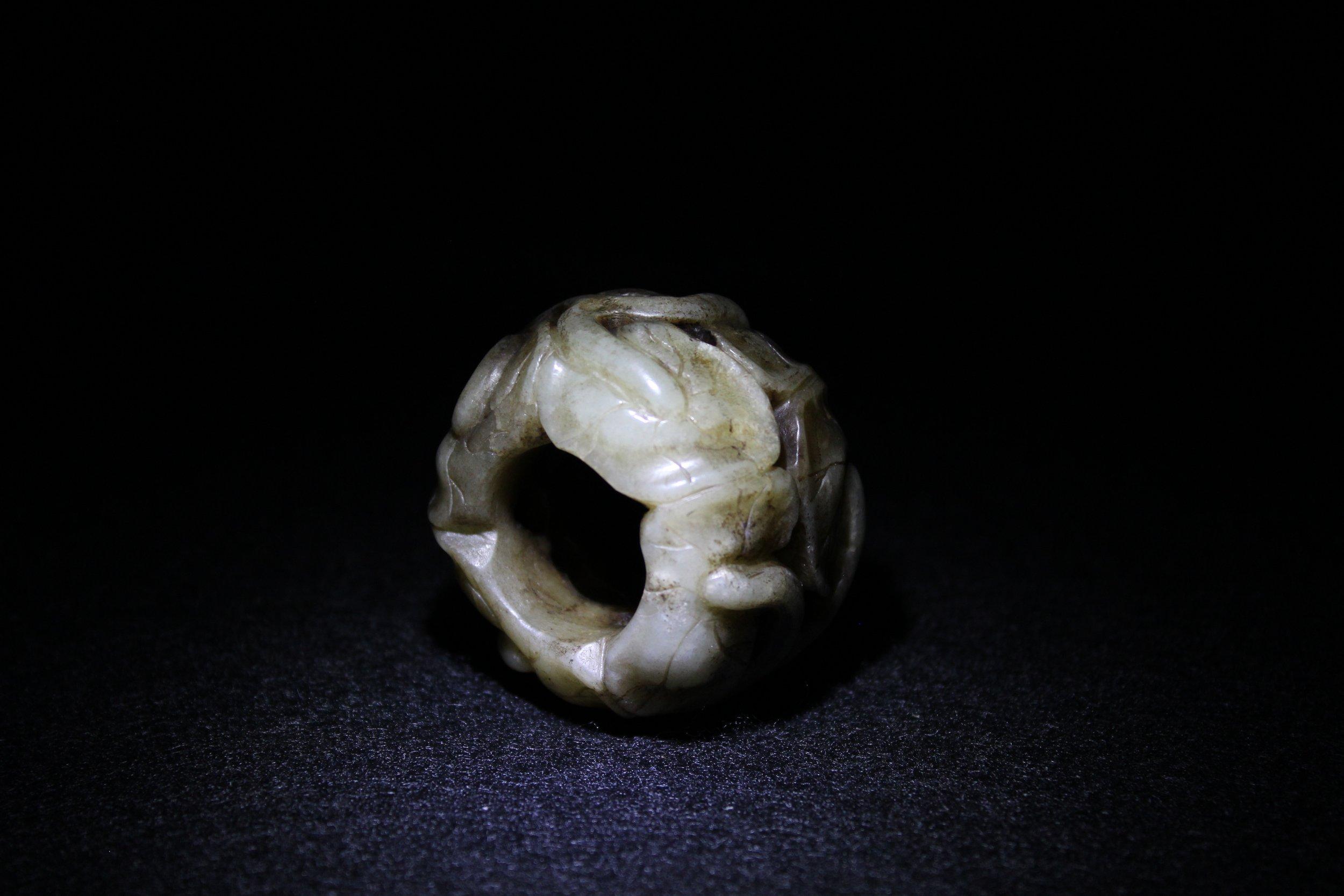 Cet épi de faîtage, destiné à orner une lampe ou un meuble, est composé de huit feuilles de lotus ondulantes et imbriquées. Le jade noir, grisâtre et roux était populaire sous la dynastie Ming en raison de la rareté des sources de jade. Les artistes