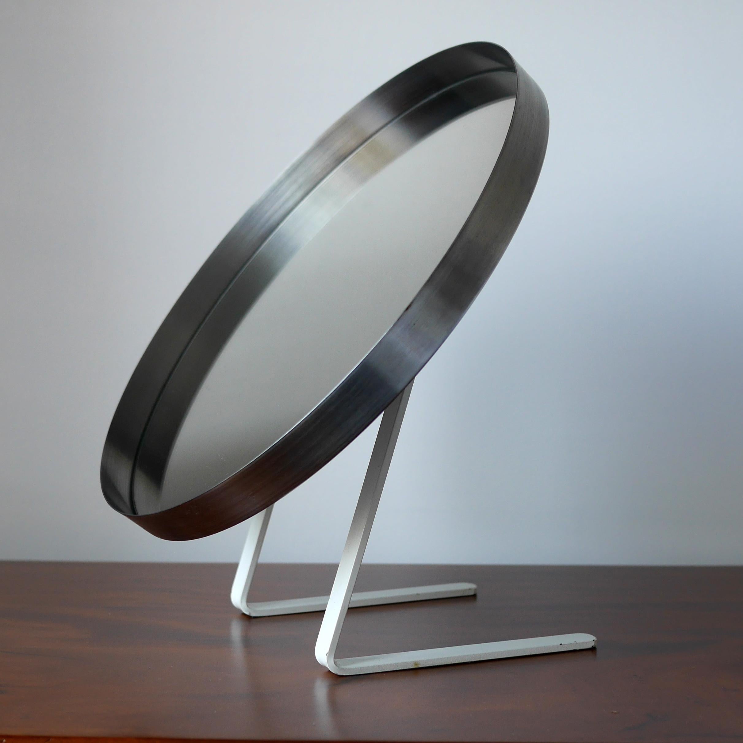 A rare vanity mirror by Owen F. Thomas for Durlston design Ltd circa 1968 in lovely original condition. Crafted from stainless steel with a lovely combination of steel mirror frame and original white enamel finish to the frame. The circular framed
