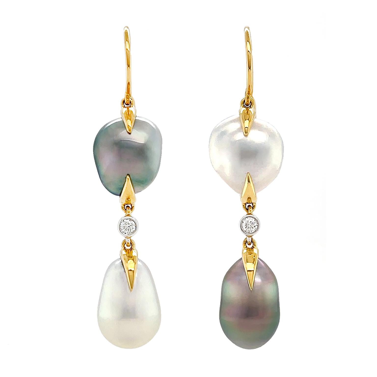 Using cool toned baroque keshi pearls, these earrings have 18k yellow gold hooks holding a round shaped pearl and elongated pearl with a brilliant set diamond in between. One earring has a white pearl on top and Tahitian keshi pearl at the bottom