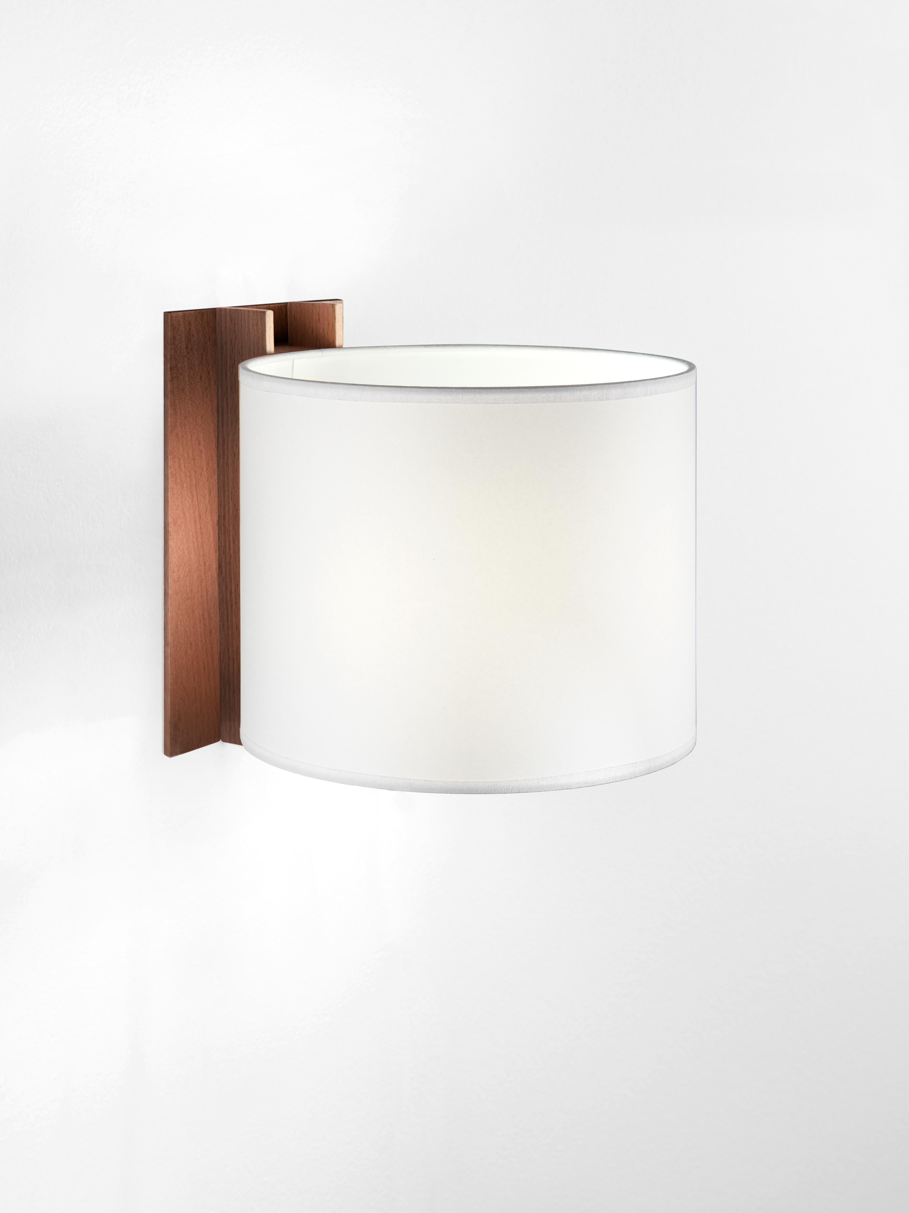 White and walnut TMM corto wall lamp by Miguel Milá
Dimensions: D 20 x W 23 x H 20 cm
Materials: Metal, walnut wood, parchment lampshade.
Direct wall.
Available in beech or walnut and in white or beige lampshade.
Available with plug or direct