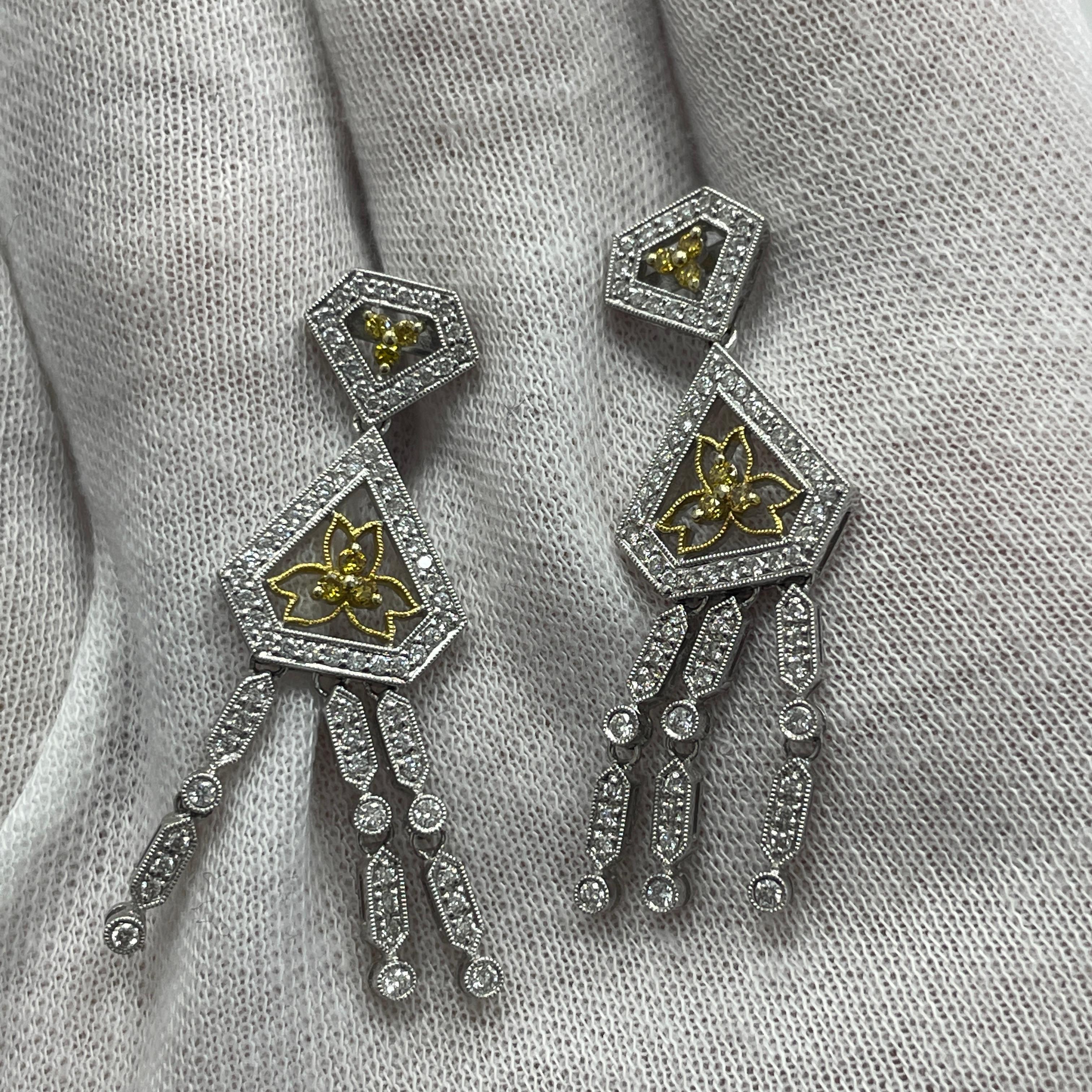 These elegant 18K white and yellow gold dangling earrings carry 0.84Ct of white diamonds and 0.17Ct of yellow diamonds