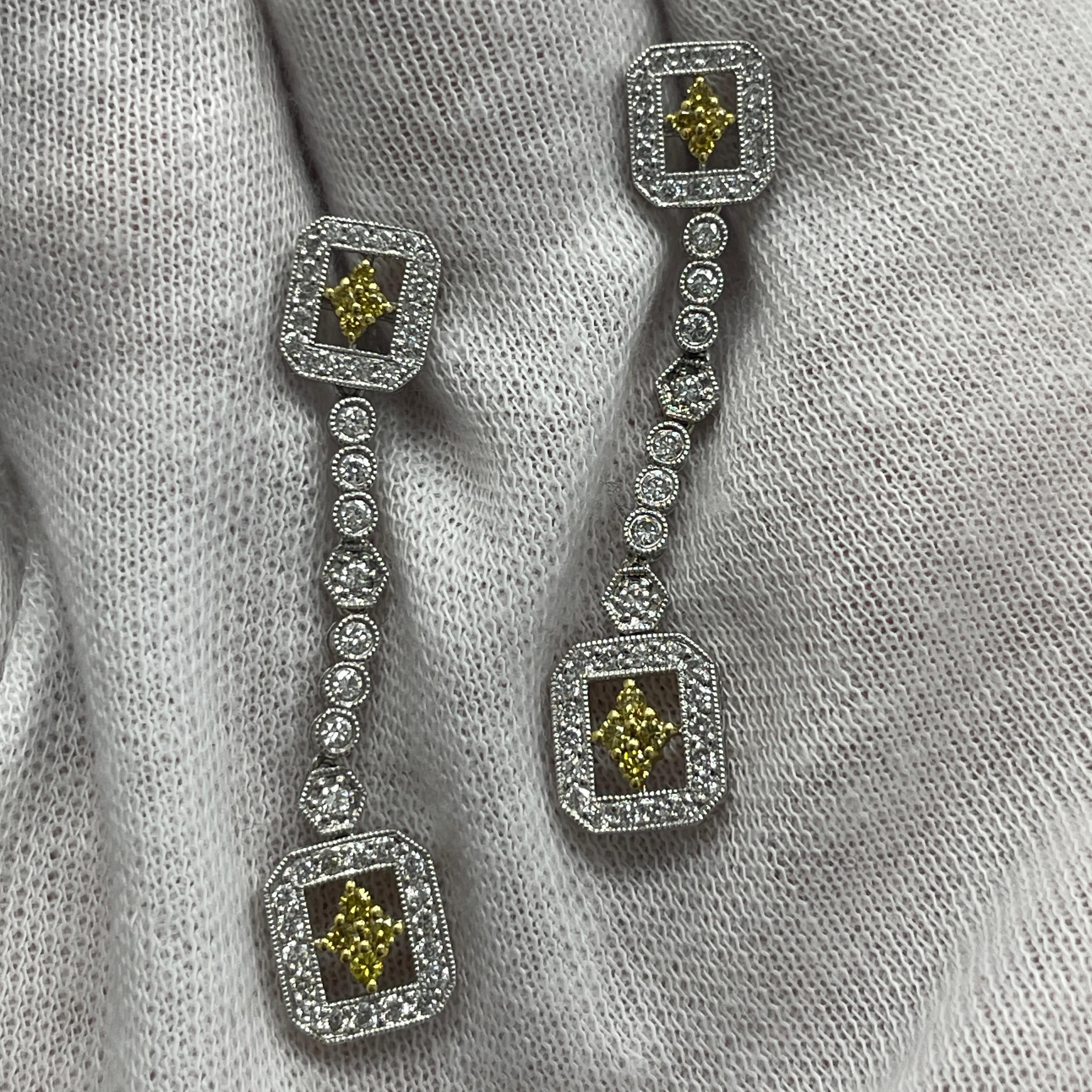 These elegant 18K white and yellow gold dangling earrings carry 0.22Ct of white diamonds and 0.77Ct of yellow diamonds
