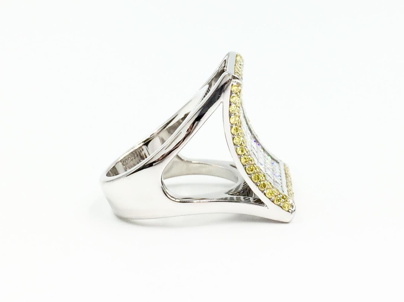 Exceptional quality and unique modern design by designer Sasha Primak. This curved 18 karat white gold ring features expertly invisibly set white princess cut diamonds and a pavé set fancy yellow diamond border. with 3.90 carats total weight. High