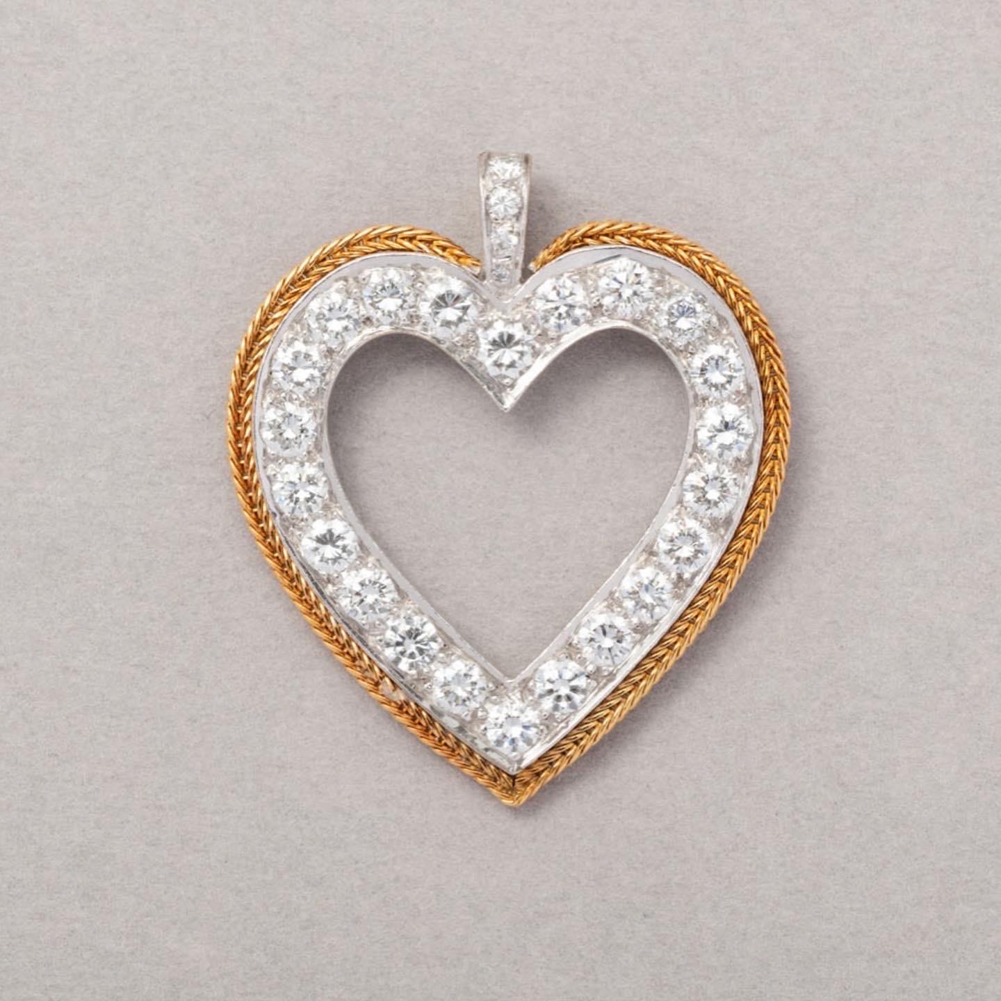 An 18 carat gold heart shaped pendant witn open white gold heart set with brilliant cut diamonds contoured by a yellow gold woven gold outline (circa total 2.2 ct.), with French assay marks for 18 carat gold, circa 1970, possibly English in