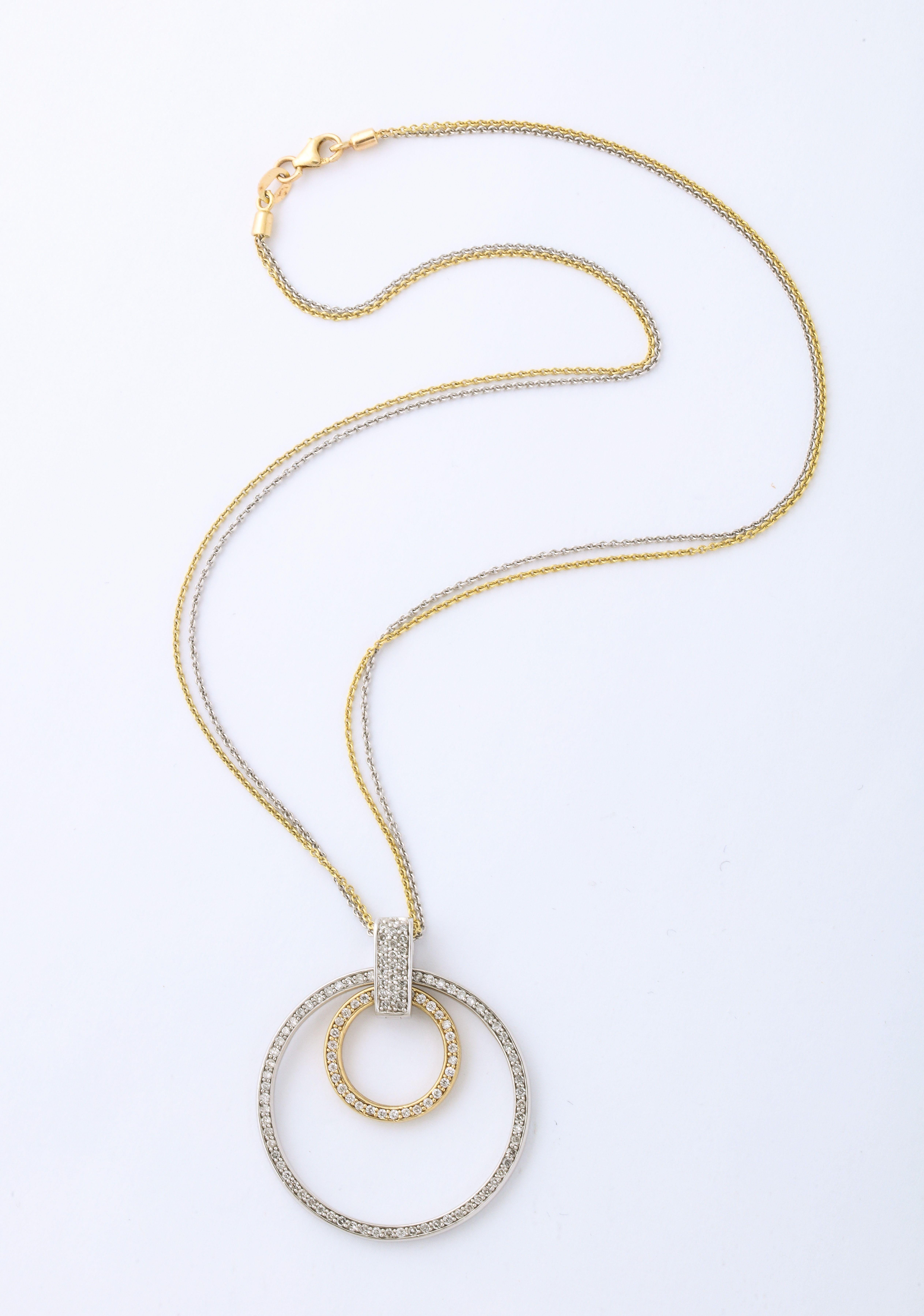 A great White and Yellow Gold Diamond Necklace with two rings linked by a diamond encrusted gold clasp suspended by a yellow gold chain