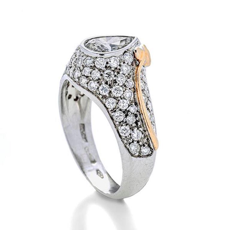 White gold ring made with a pear cut Diamond on a base embellished with a diamond pavè and stylized yellow gold leaf.

Pear Cut Diamond 0.80 carats, color J, clarity VS2

Brilliant Cut Diamonds total of 0.80 carats, H color, VS clarity