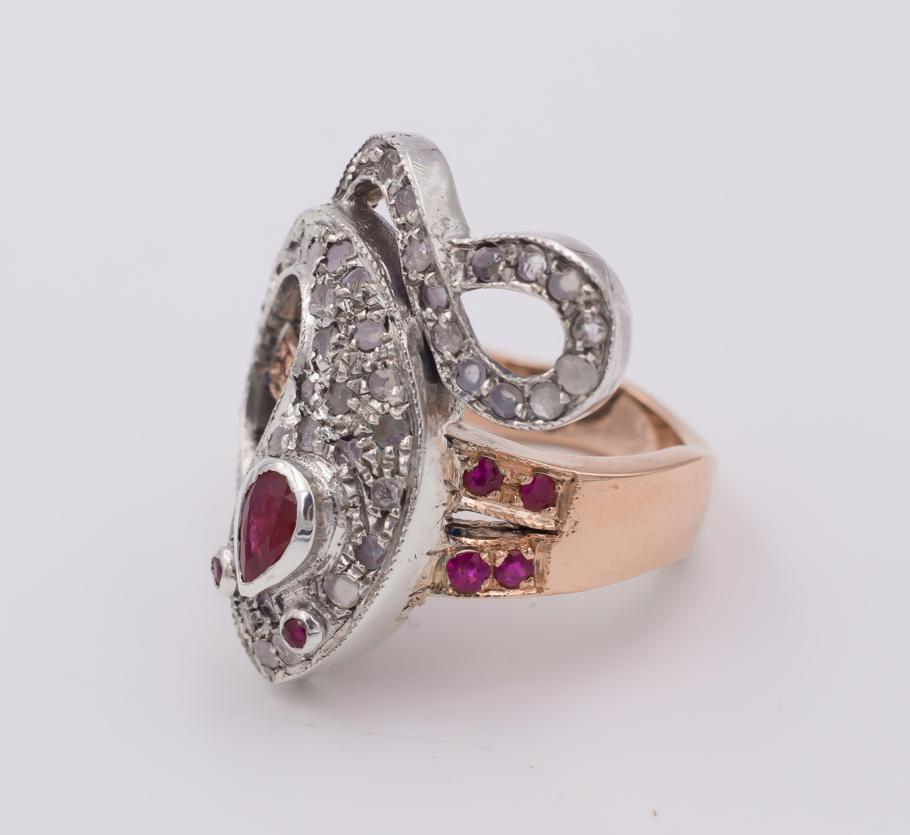 This stunning ring is modern and is crafted both in yellow and white gold. 
The head of the ring has the shape of a snake, modelled in white gold throughout: the entire body of the reptile is decorated with rose cut diamonds; two rubies are the