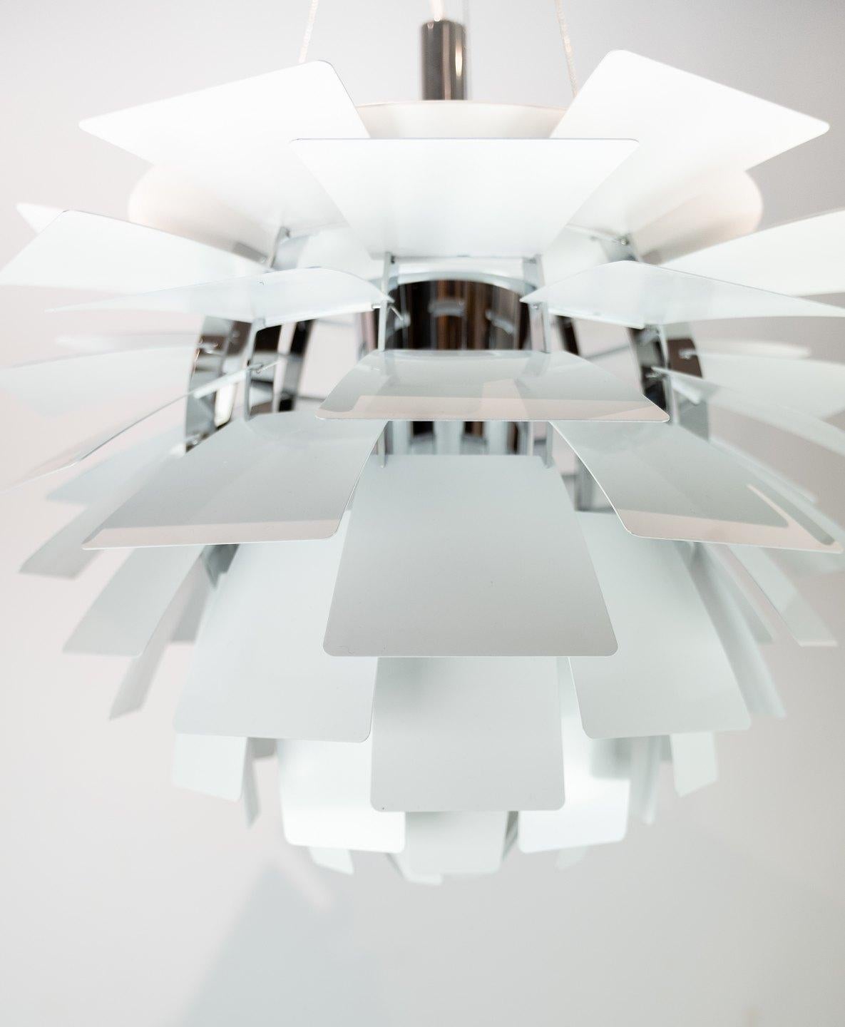 La suspension White Artichoke, conçue par l'emblématique Poul Henningsen en 1958 et fabriquée par Louis Poulsen, est un chef-d'œuvre de l'éclairage scandinave. Sa forme distinctive, qui rappelle les pétales superposés d'un artichaut, dégage une