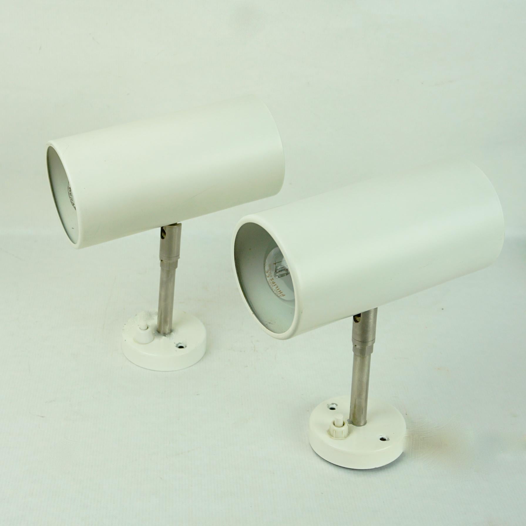 This minimalistic and pure Austrian Midcentury zylindrical pair of wall lights were designed and manufactured by J. T. Kalmar in the 1960s in Vienna Austria.
They feature zylindtical white lacquered metal shades on a stainless steel base. The shade
