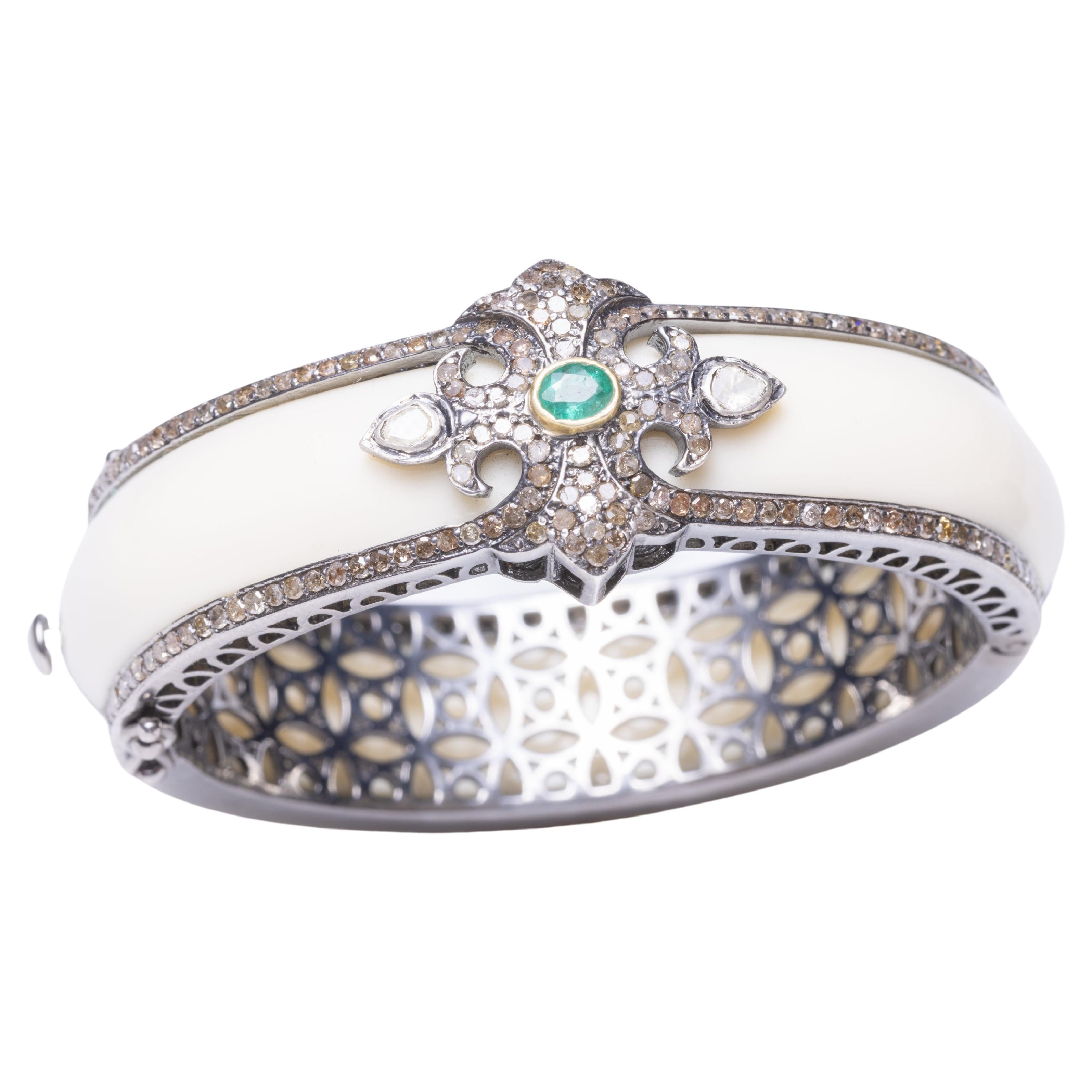 A stunning cuff bracelet in white Bakelite bordered on both sides with pave` set diamonds.  The top features additional pave` set diamonds with an oval, faceted emerald and two rose-cut diamonds on each side.  Inside circumference is 6 1/8th inch. 