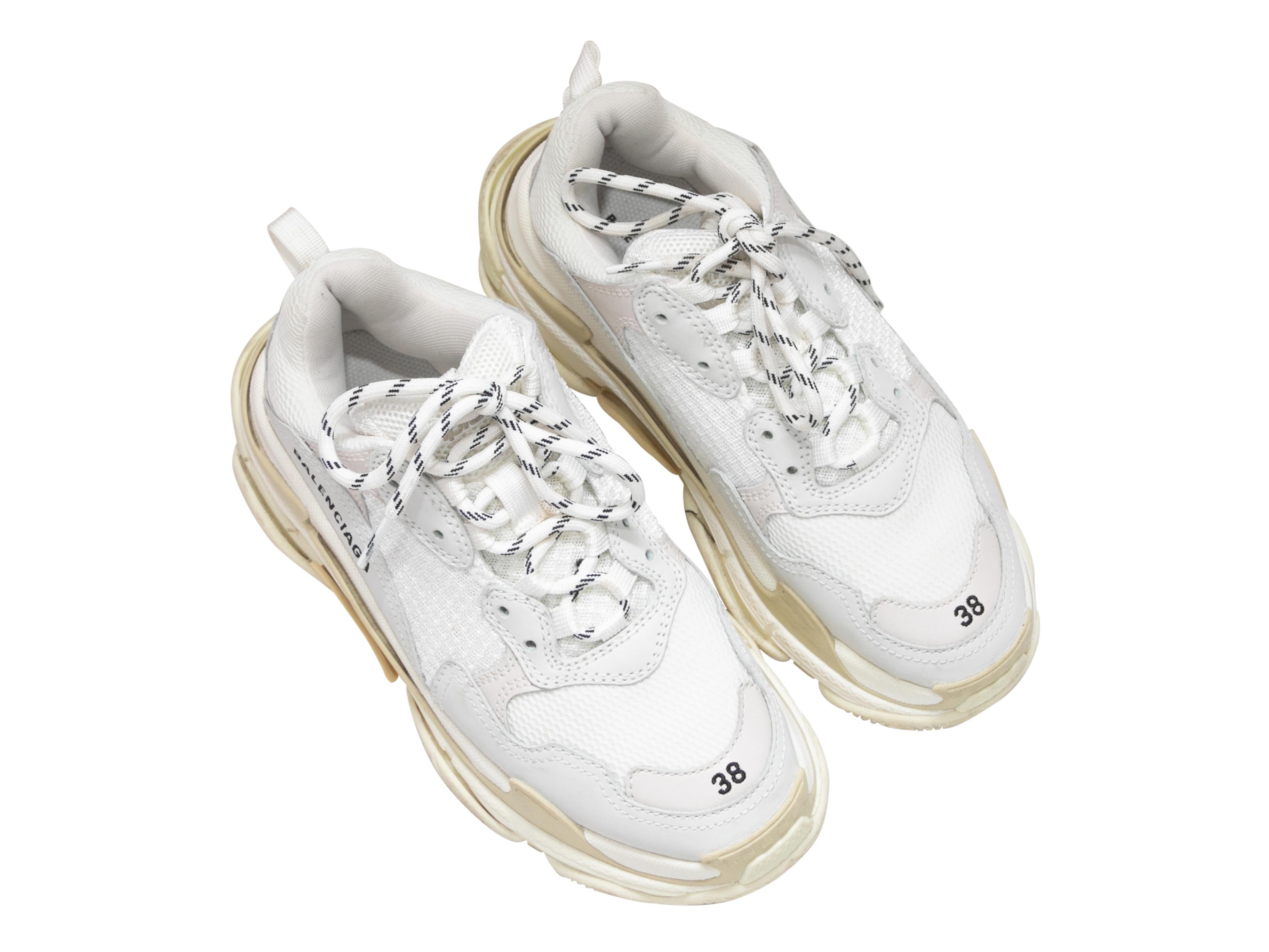 Product Details: White chunky platform Triple S low-top sneakers by Balenciaga. Foam rubber soles. Lace-up tie closures at tops. 1.5