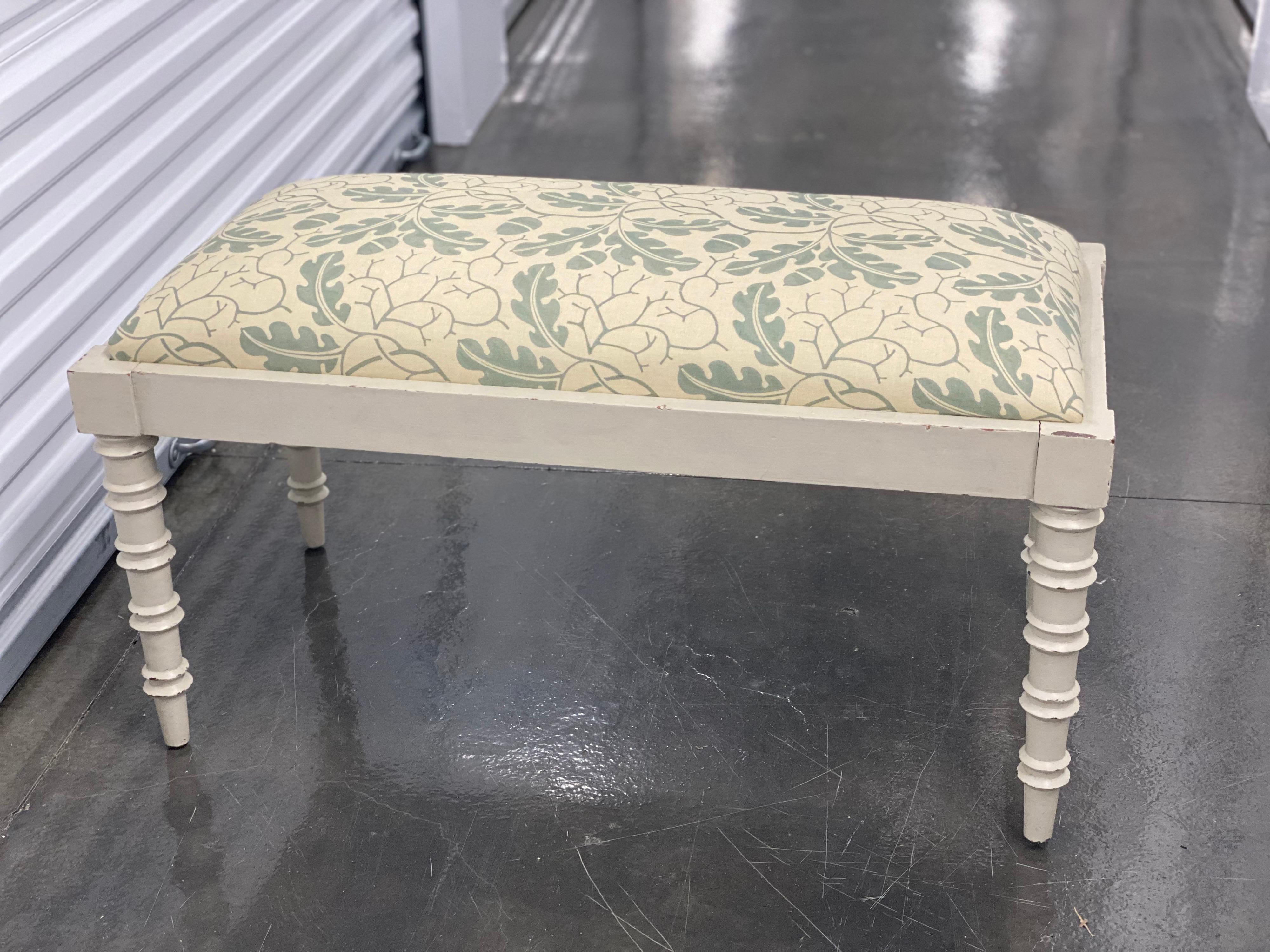 White bamboo style painted bench covered in Robert Kime Oak Leaf fabric.
This bench features a rectangular upholstered drop-in seat covered in Robert Kime Oak Leaf Fabric . The bench frame has four turned legs, mimicking a faux bamboo style, which