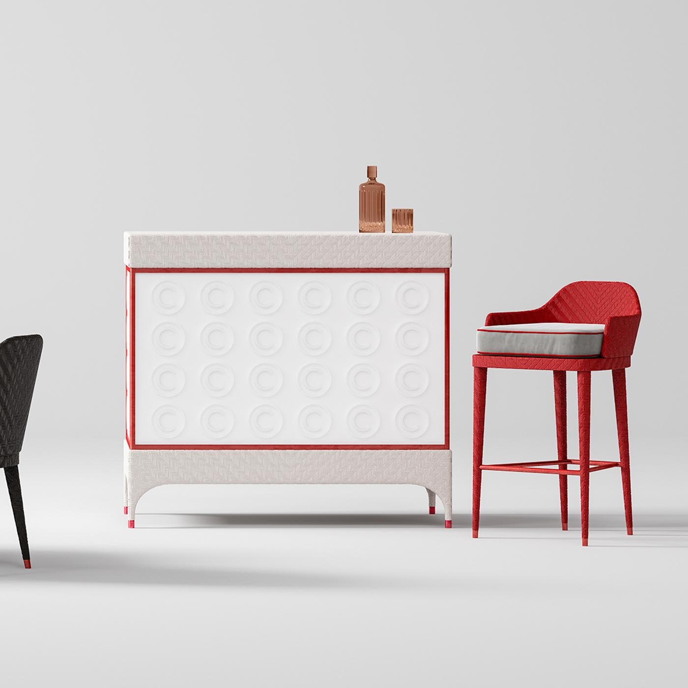 An elegant design that combines functionality and visual appeal, this bar cabinet is the ultimate accessory for any outdoor decor. Constructed on an aluminum frame covered with handwoven resin, the compact white silhouette features red profiles