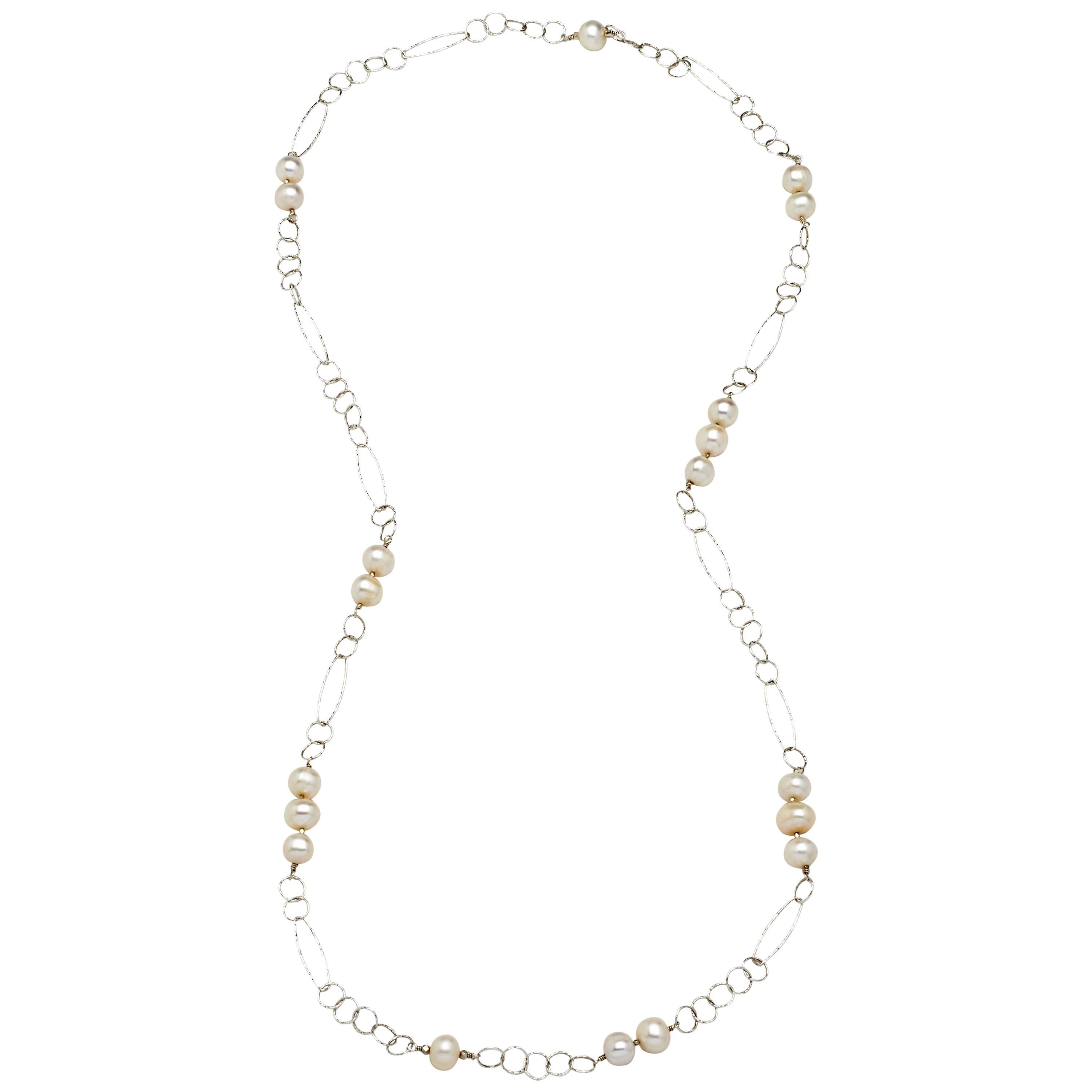 A fresh summer look, lustrous natural AA white off round button pearls integrated with lengthy, shimmering open link sterling silver chain create this
stunning necklace. Measuring 32