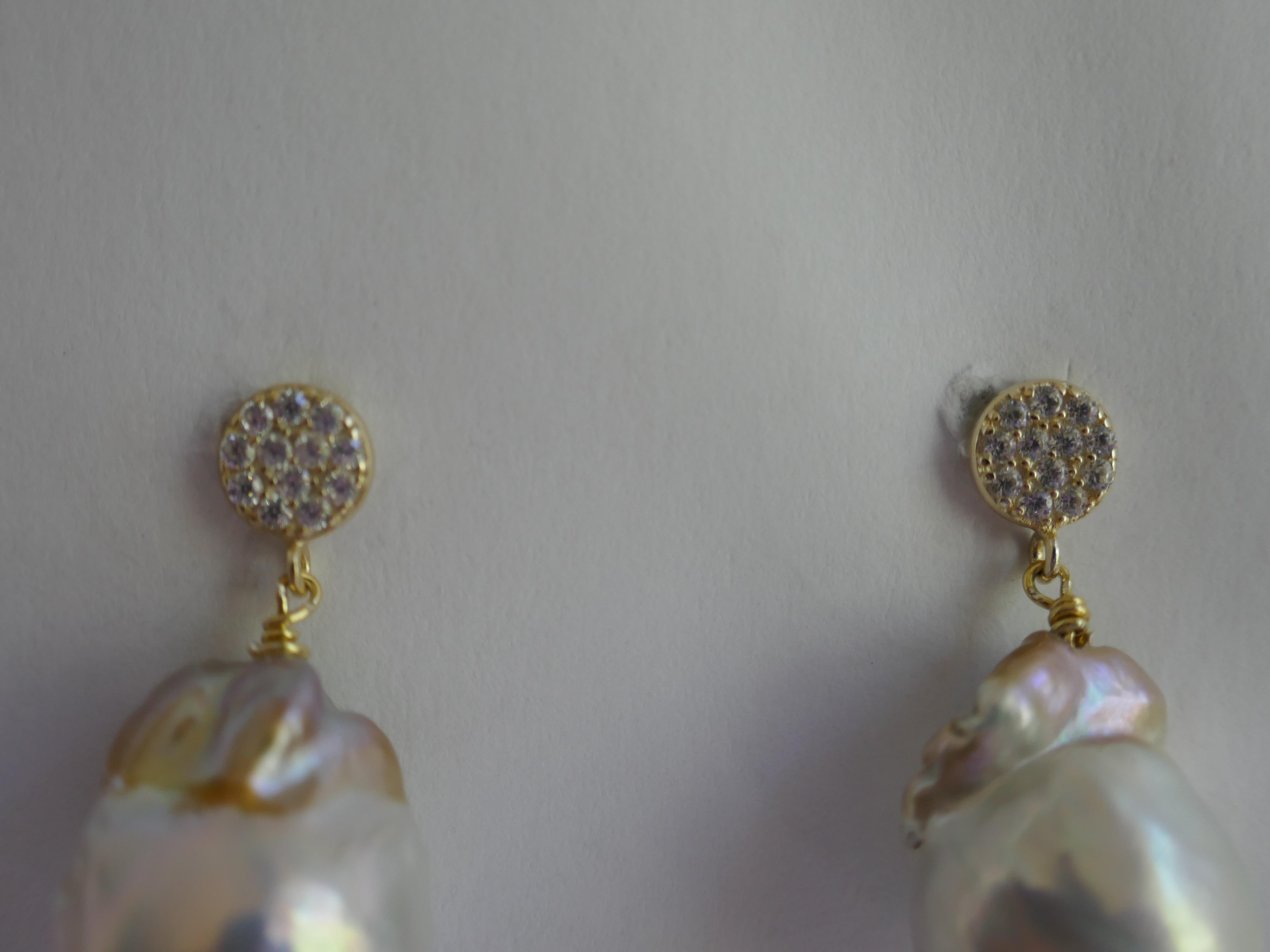 The earrings are white baroque cultured pearls with a little gold tone as seen in the picture. The size of the pearls is approximately  14mm  x 18mm  The post are vermeil cubic zirconia 7mm with push backs screw backs. The earrings are 1 3/8  inches