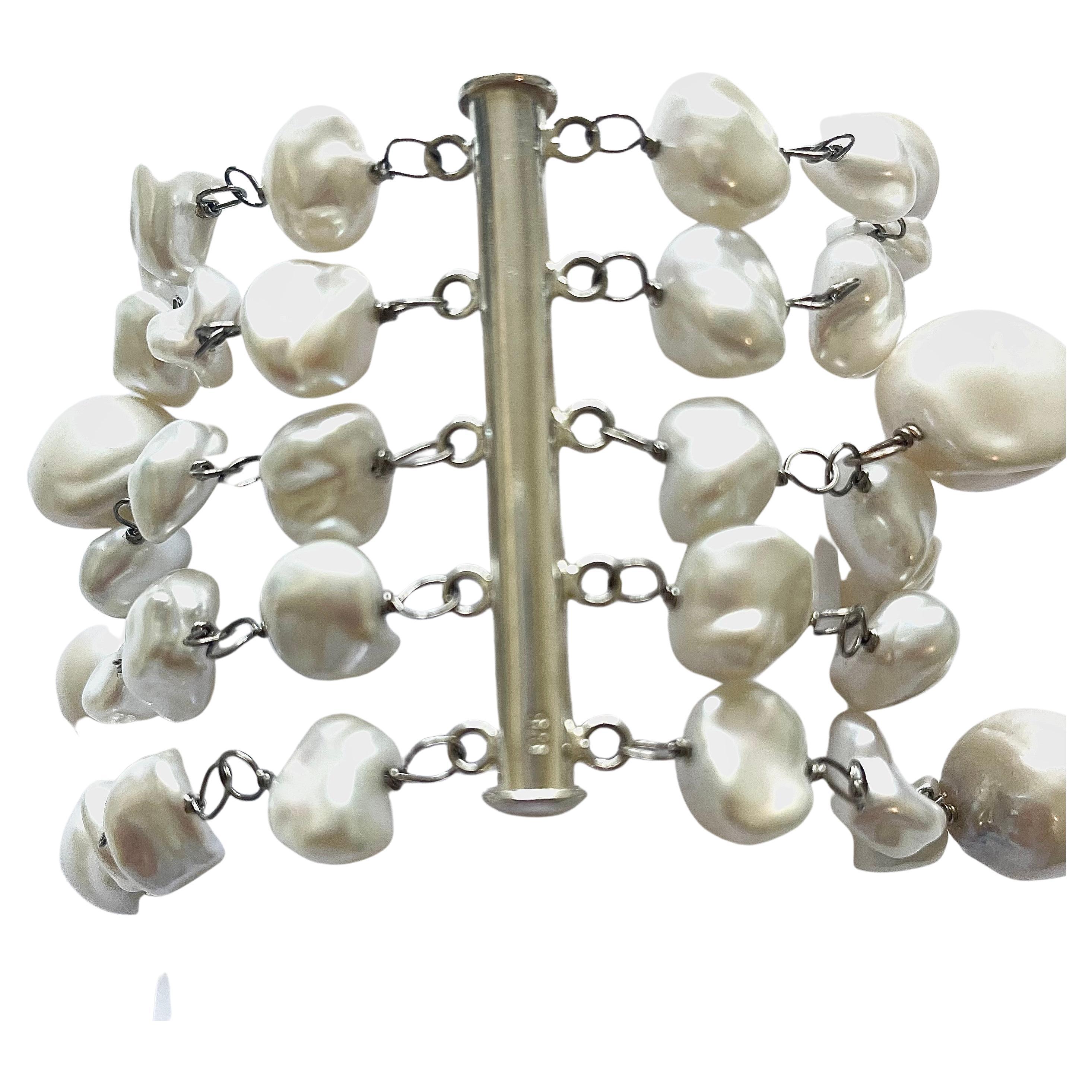 Description
White freshwater pearls. Five strand bracelet.         
Item # B1056

Materials and Weight
Freshwater Keshi pearls (55 pieces), 10mm.
Freshwater Baroque pearls (13 pieces), 13 to 15mm.
14k white gold with palladium.
Sterling silver