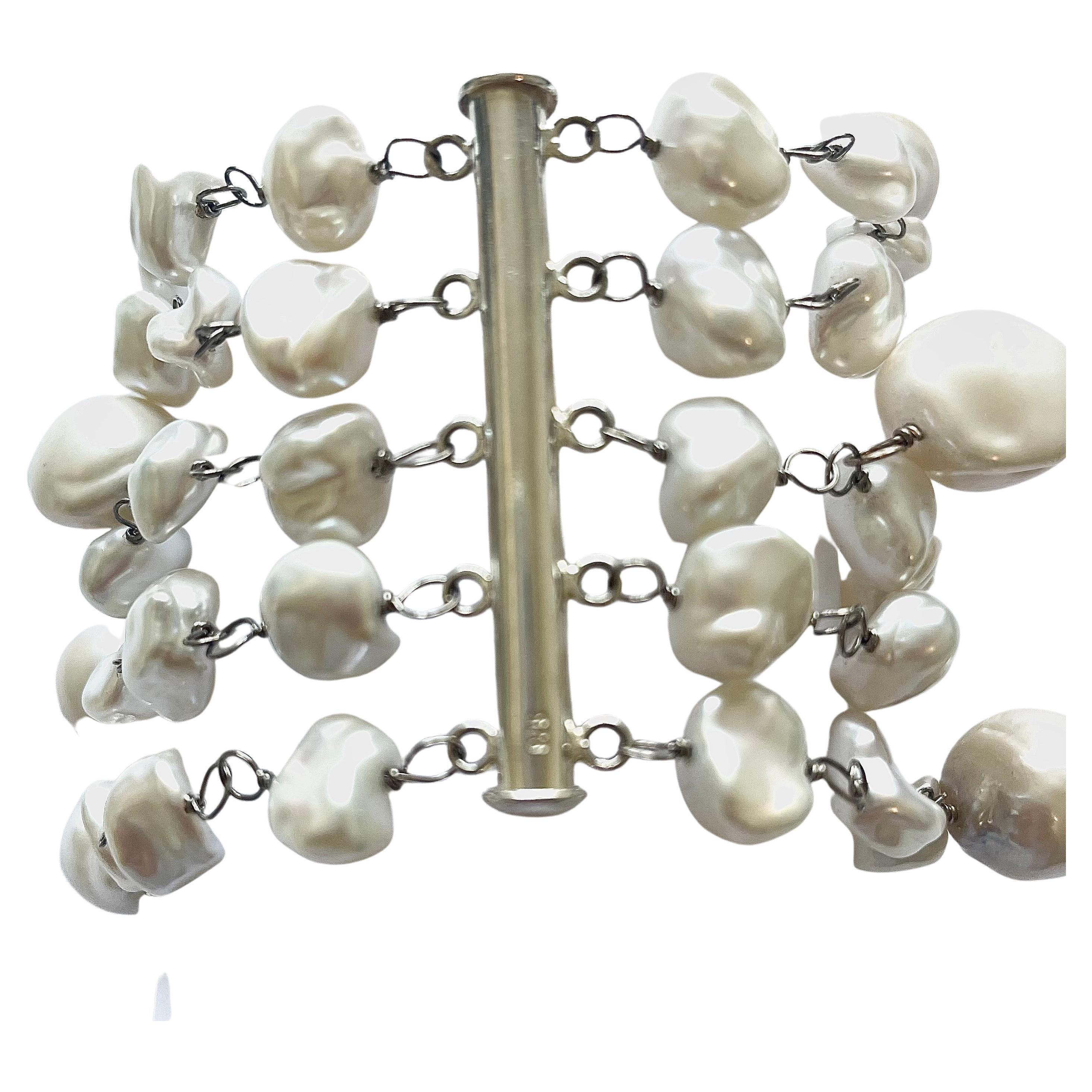 Description
Perles d'eau douce blanches. Bracelet à cinq brins.         
Article # B1056

Matériaux et poids
Perles d'eau douce Keshi (55 pièces), 10mm.
Perles baroques d'eau douce (13 pièces), 13 à 15 mm.
or blanc 14k avec palladium.
Fermoir