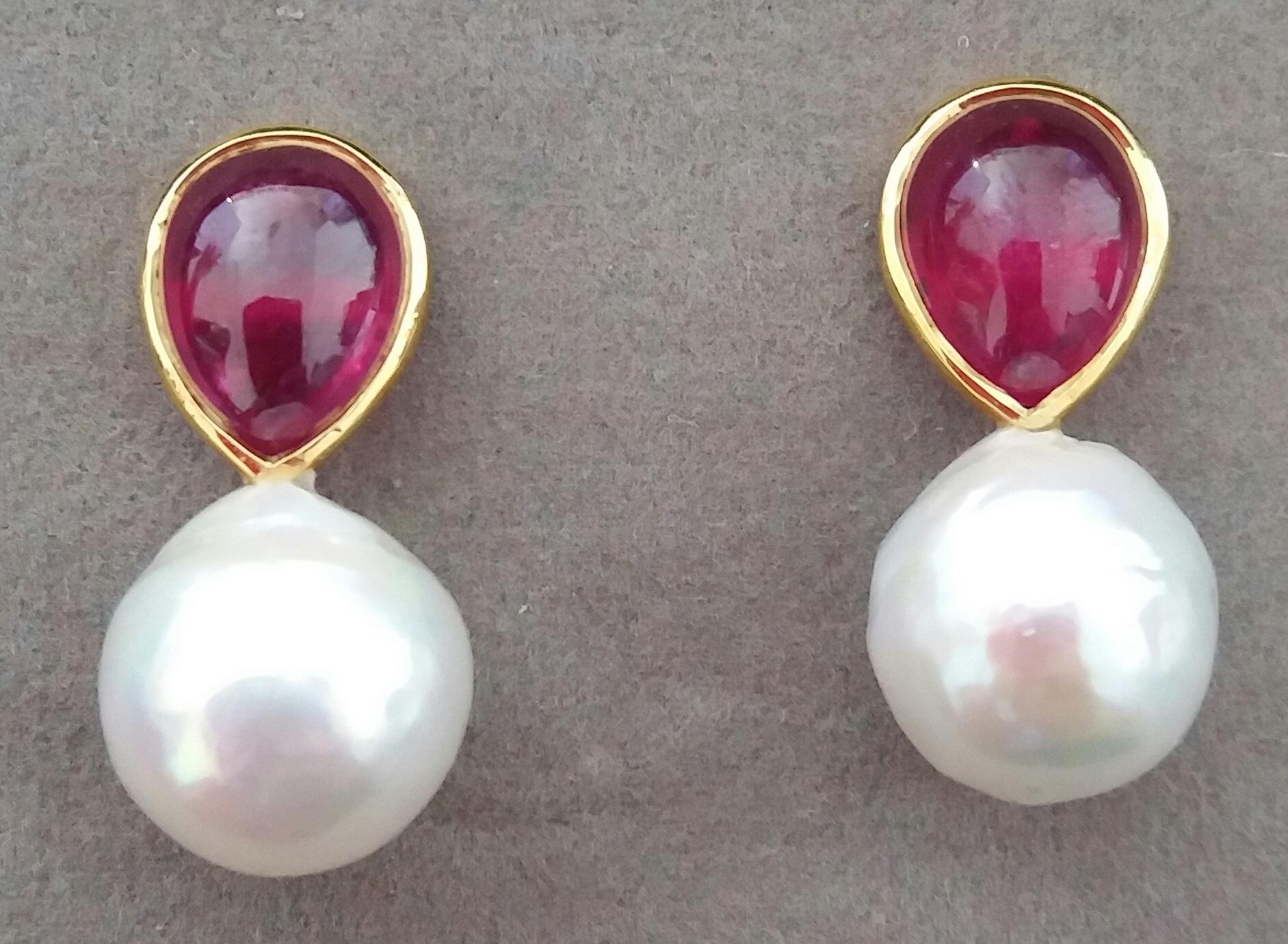 These simple chic and handmade stud earrings have a pair of Pear Shape Ruby Cabs measuring 9 x 11 mm and weighing 8,7 carats set in solid 14 Kt. yellow gold bezel on the top and in the lower parts 2 excellent luster White Baroque Pearls measuring 13
