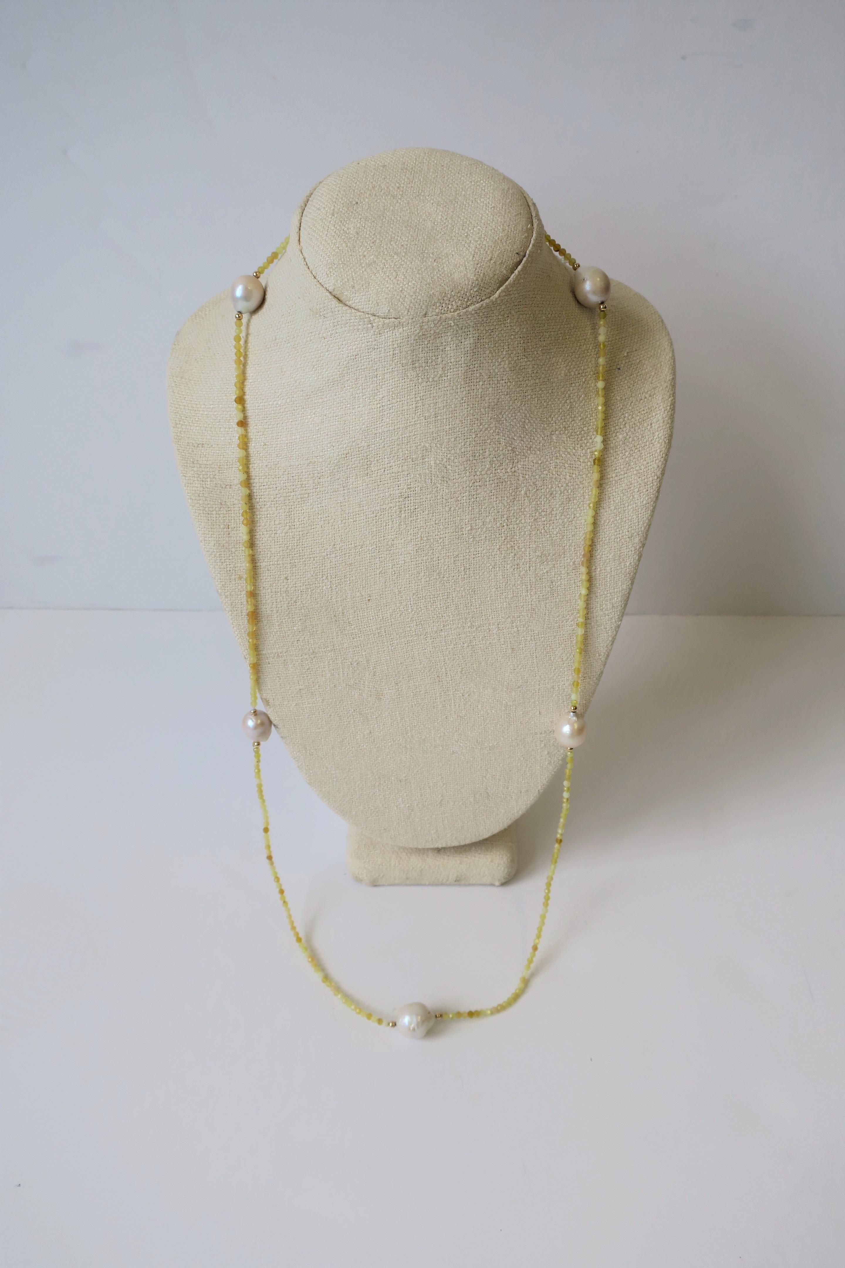A very beautiful long necklace of real, relatively large, 5 white baroque freshwater pearls, 14-karat gold beads and yellow tumbled stone beads. Dimensions: 34.5