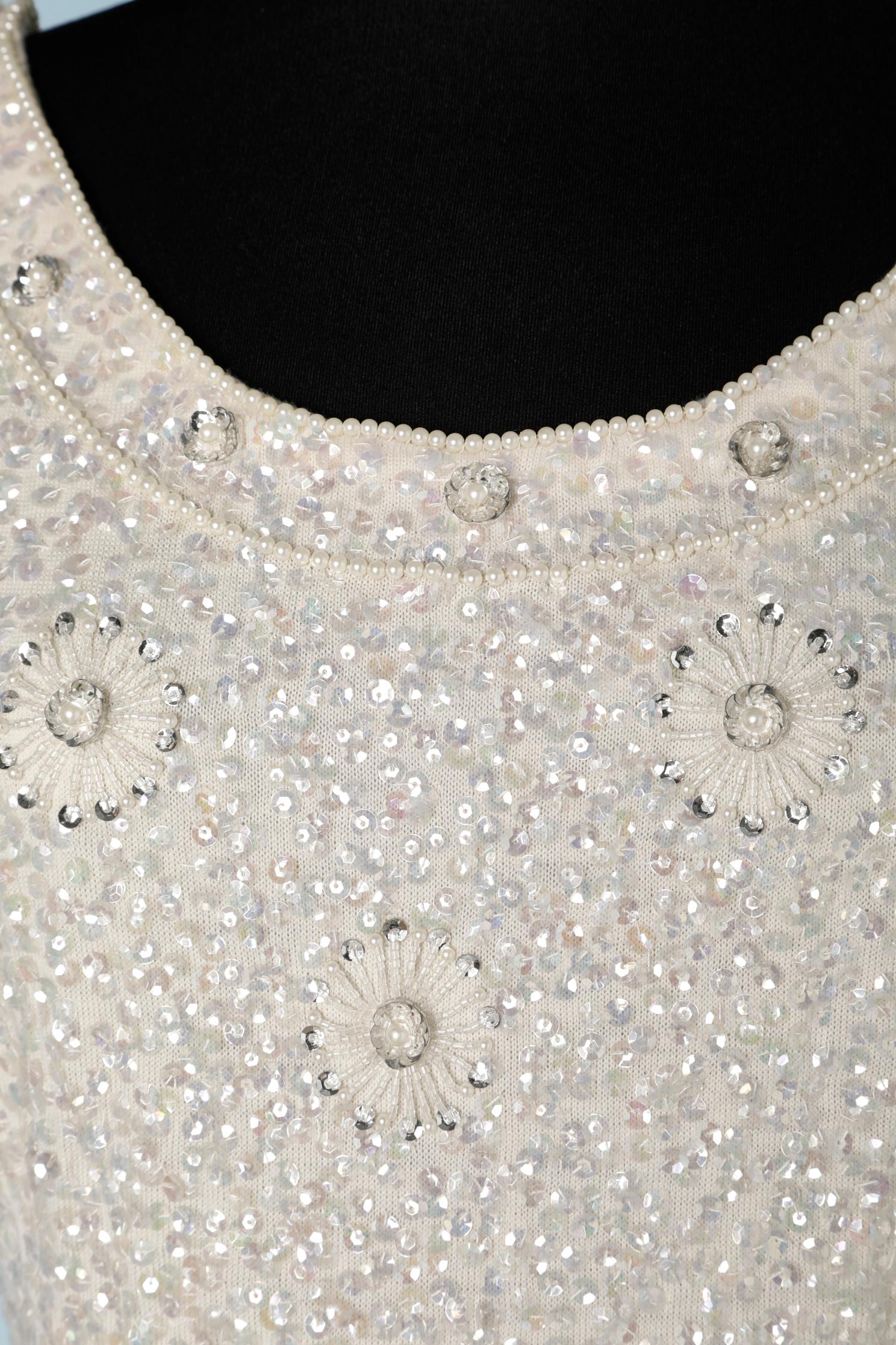 White beaded and sequin cocktail dress on wool jersey base. No fabric composition for the lining but probably acetate or rayon. 
Zip closure in the middle back and one hook&eye on the top. 
SIZE 38 / M 