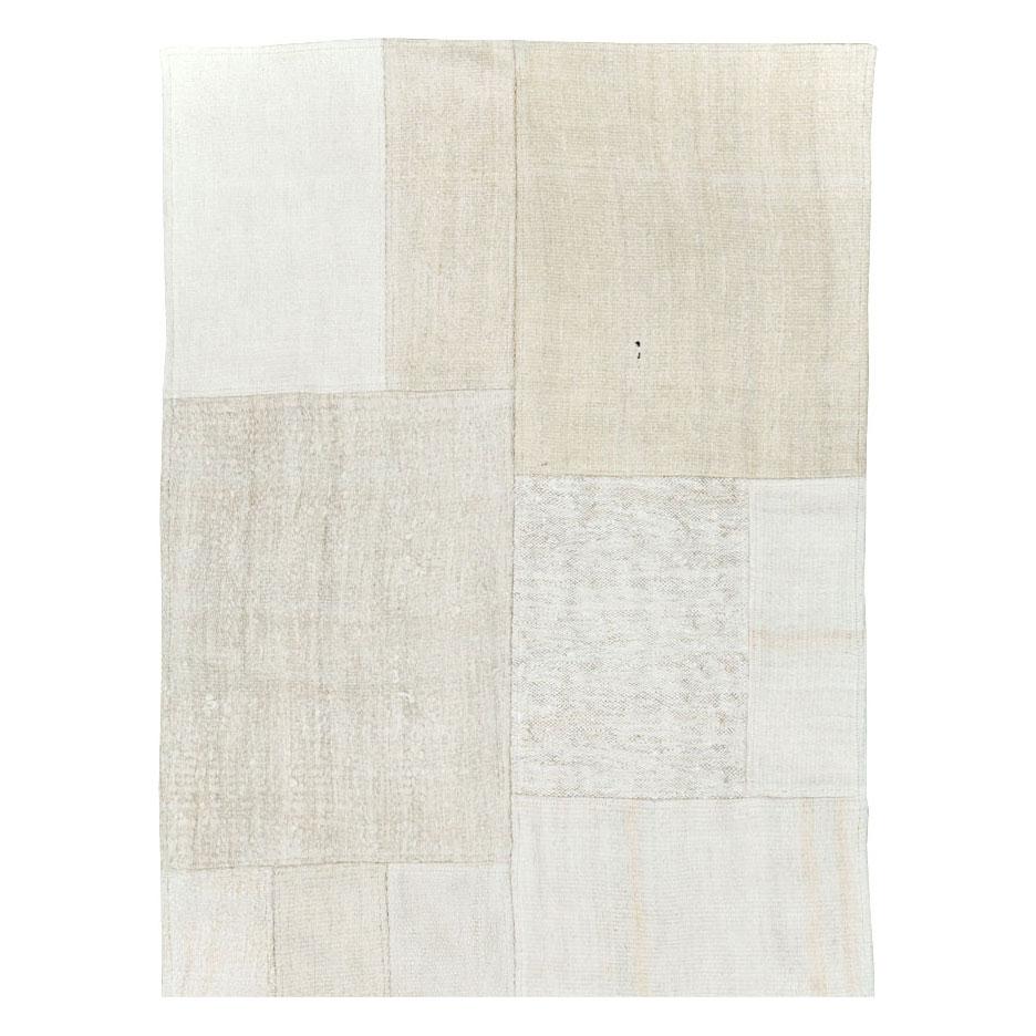 A contemporary Turkish flatweave Kilim runner handmade during the 21st century in shades of white and beige. This patchwork style rug consists of hand-weaving together several remnants of vintage Kilim carpets from the mid-20th century