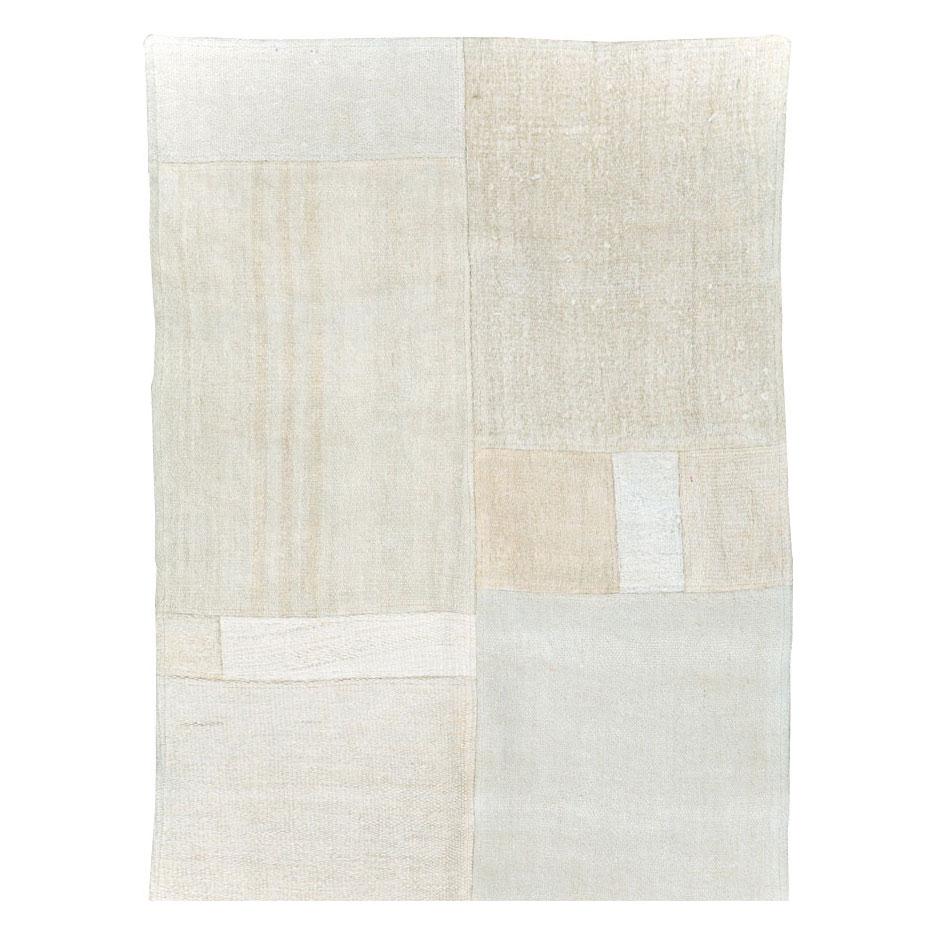 Un runner Kilim turco contemporaneo a trama piatta realizzato a mano nel XXI secolo nei toni del bianco e del beige. Questo tappeto in stile patchwork consiste nell'intrecciare a mano diversi resti di tappeti Kilim vintage della metà del XX