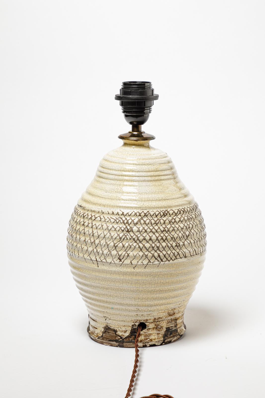 Lampe de table en céramique émaillée blanc/beige.
Circa 1930.
H : 13.8 x 6.7 pouces (avec système électrique).
H : 11 x 6.7 pouces (céramique uniquement).
Vendu avec un système électrique européen.