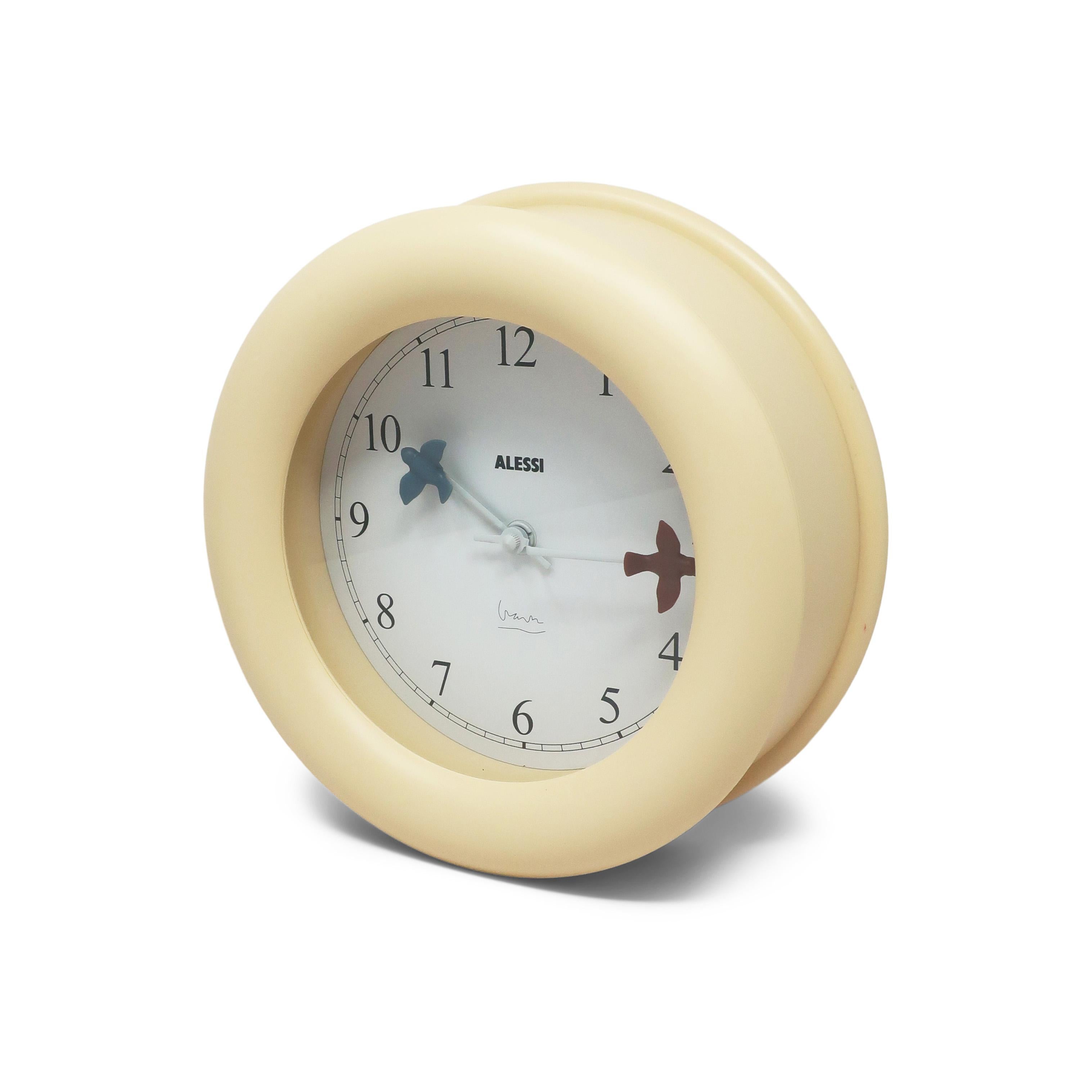 This 1992 design wall clock by Michael Graves is one of Alessi's most successful designs, along with Graves' stainless steel 9093 kettle.  The clock had a unusually deep off-white plastic body, a white face, black numbers, and blue and maroon birds