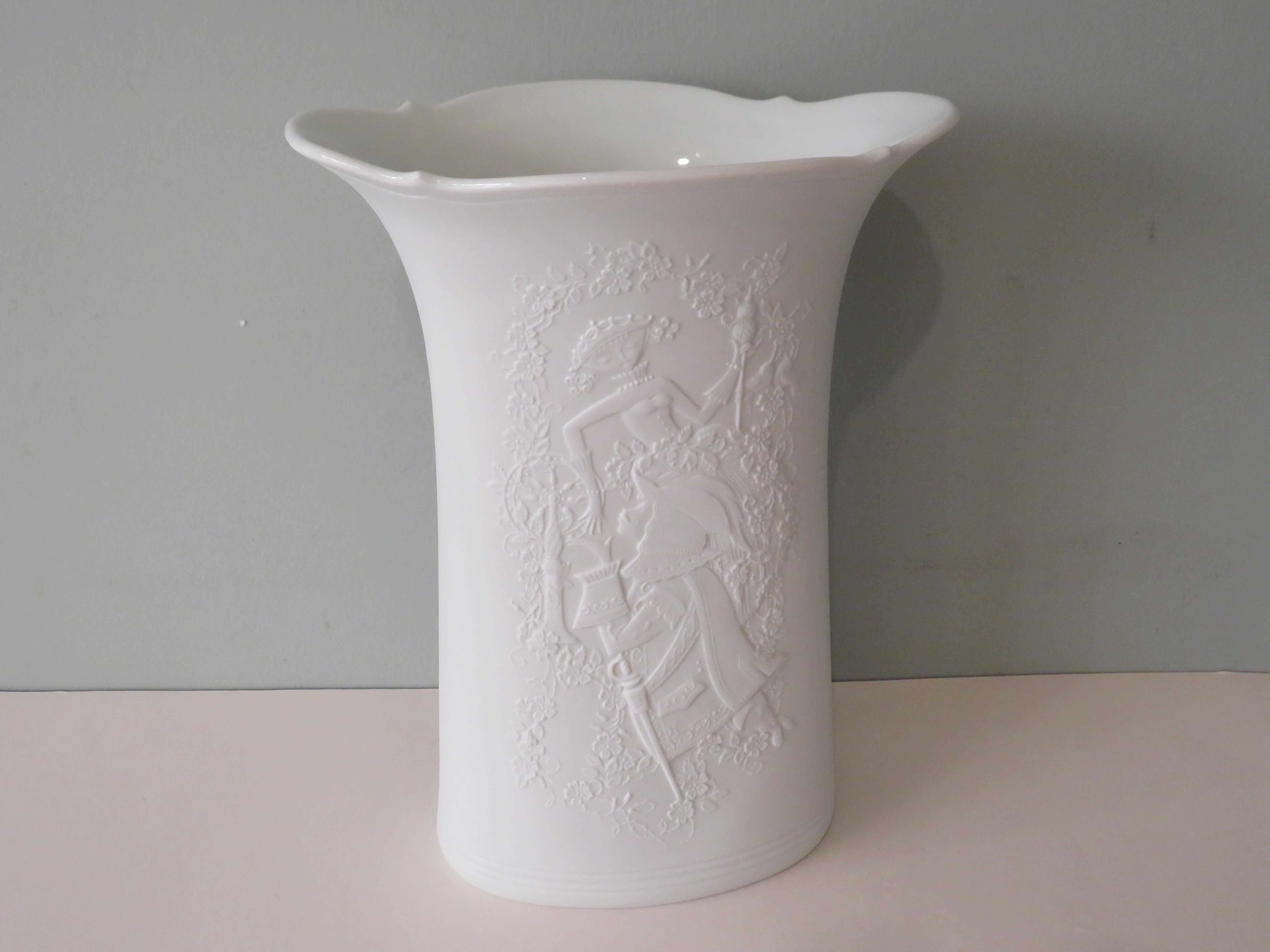 High, tapering oval vase with a curved edge and on both sides a very detailed embossed royal romantic motif of a lady and lord of the court with a background of flowers.
The vase has a matte white exterior and a glossy white interior.
The vase is