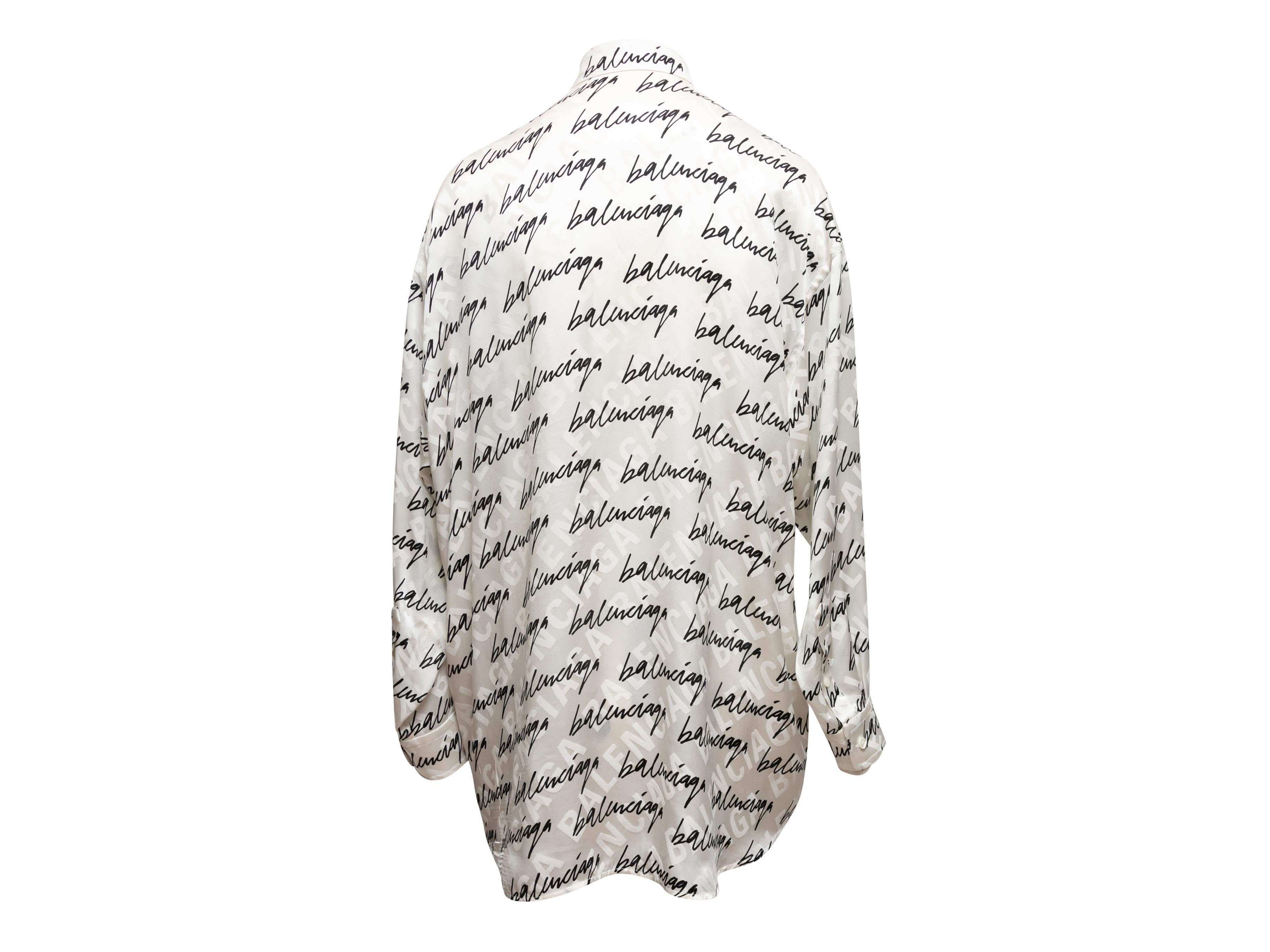 White and black silk long sleeve button-up top by Balenciaga. Cursive logo print throughout. Pointed collar. Button closures at center front. 52