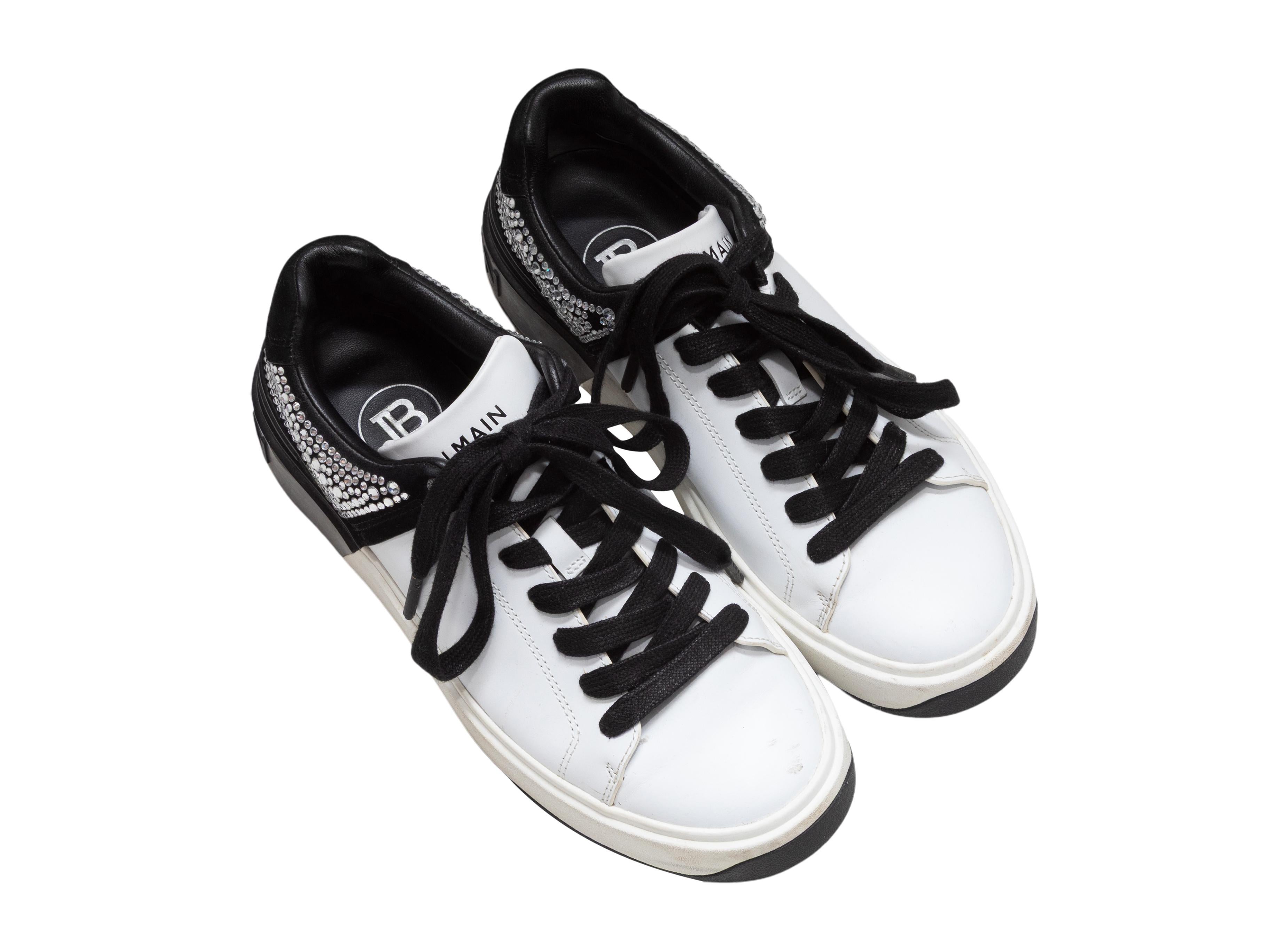 Zapatillas bajas blancas y negras de Balmain. Adornos de cristal en los mostradores. Suelas de goma. Cierres de cordones en la parte superior. Altura de la plataforma de 2,5 cm, altura del tacón de 2,5 cm.

Talla del diseñador: 37
Talla recomendada