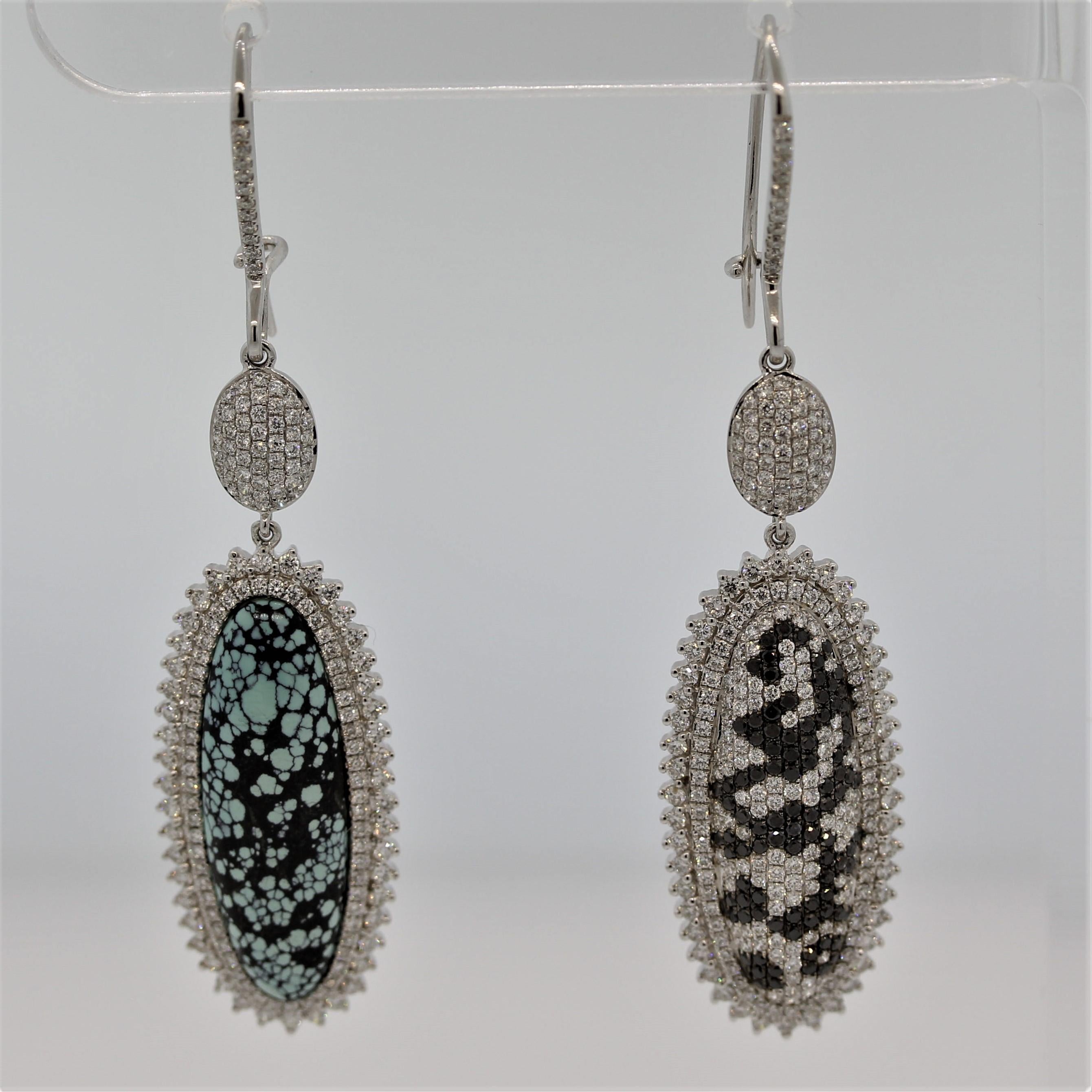 A stunning pair of earrings uniquely designed. The two earrings mirror each other in appearance but are set with different stones. Of the earrings is set with a natural turquoise with a web matrix while the other earring is set with black and white