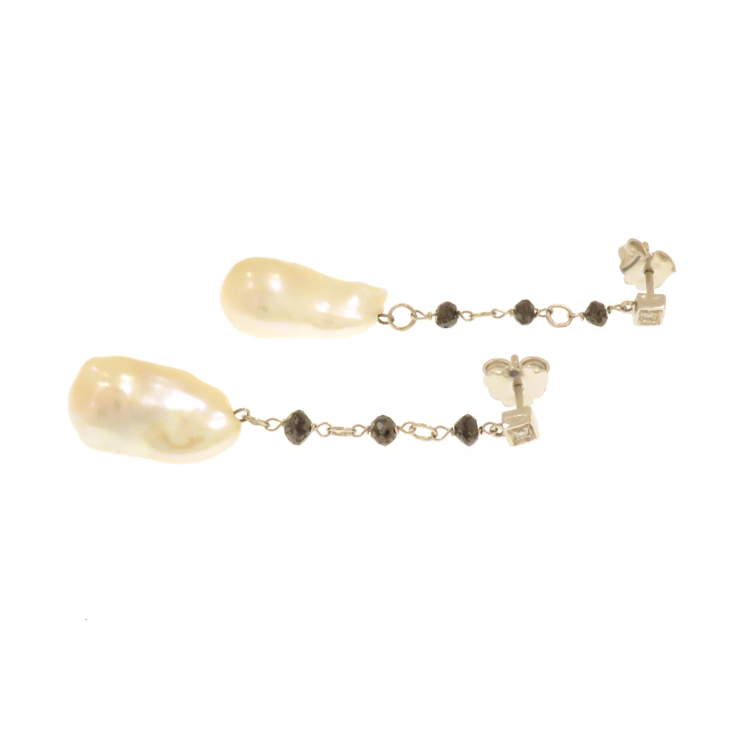 Elegant drop earrings in white 18k gold with natural freshwater white pearls. The size of the each pearl is 21x10 mm / 0.826x0.393 inches, 28.5 ctw. Both earrings include: two round cut white diamonds 0.05 ctw and six nugget cut black diamonds. The