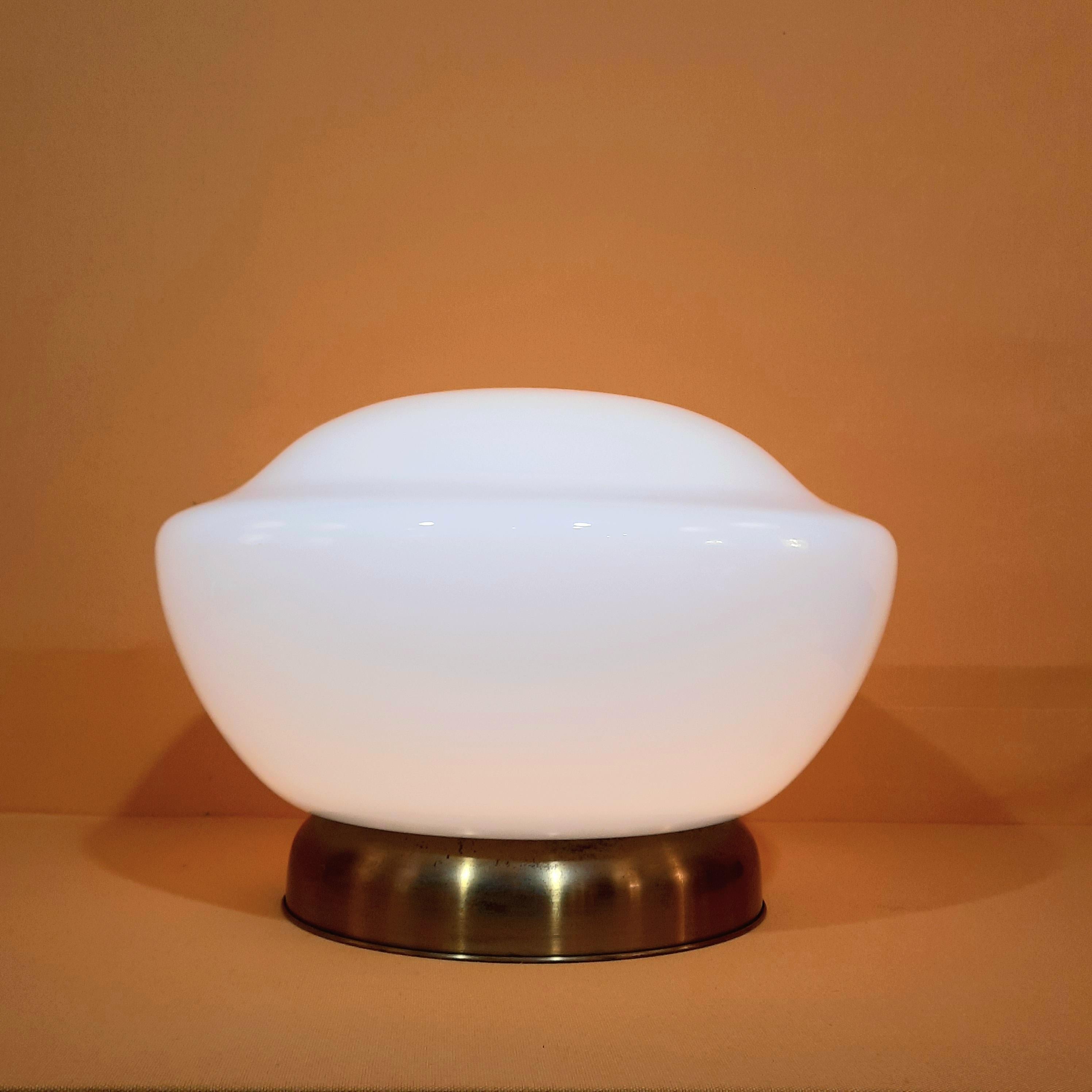 This table lamp is made of white opaline shades and brass varnished base. 
The shade is Venetian glass dated from the end of the 1960's.
Varnish on the base has worn out with time which gives it its unique patina.

Dimensions: 
Hight: 30cm
Diameter: