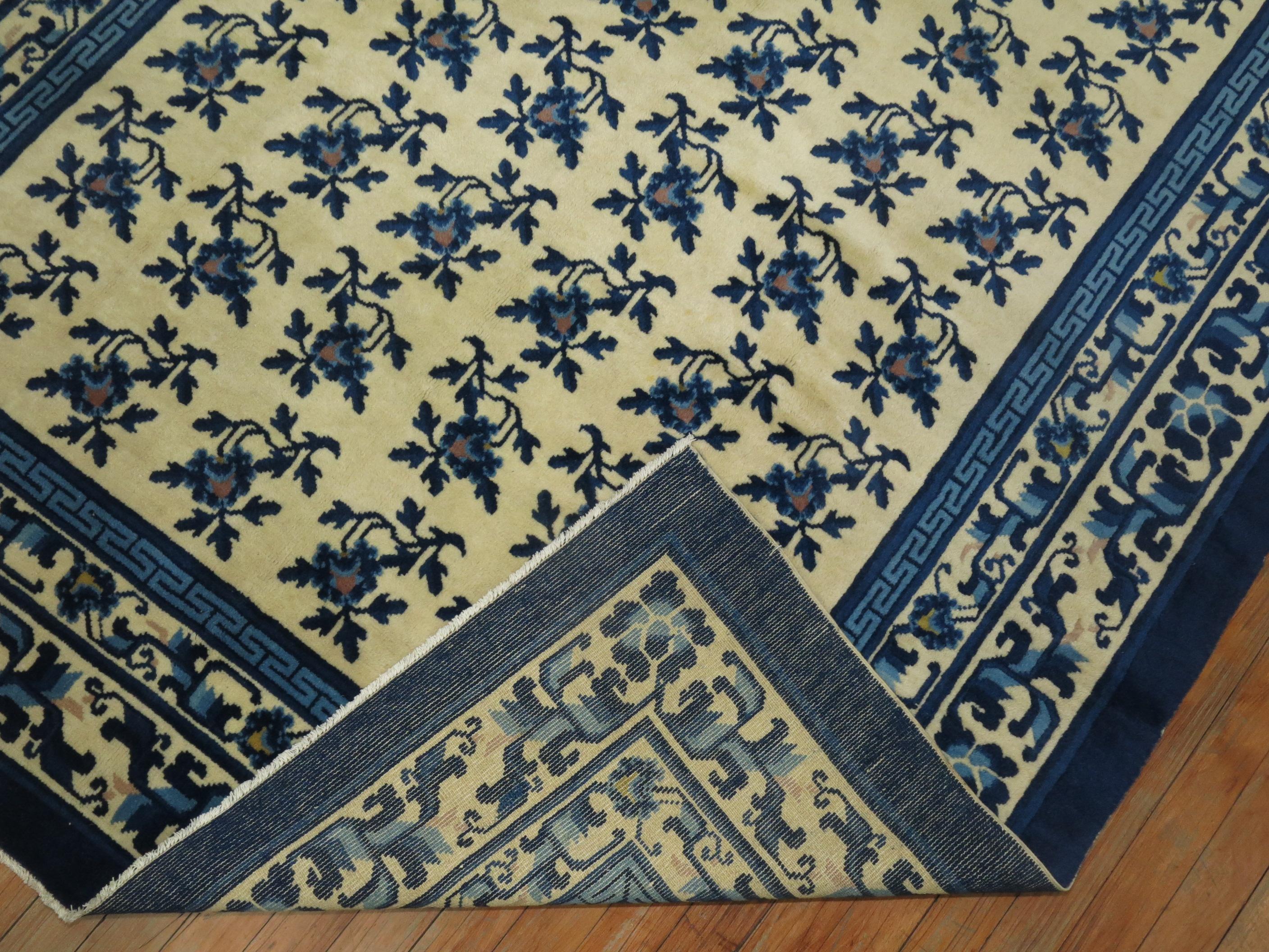 Tapis chinois vintage floral dans des tons de blanc crème et de bleu.