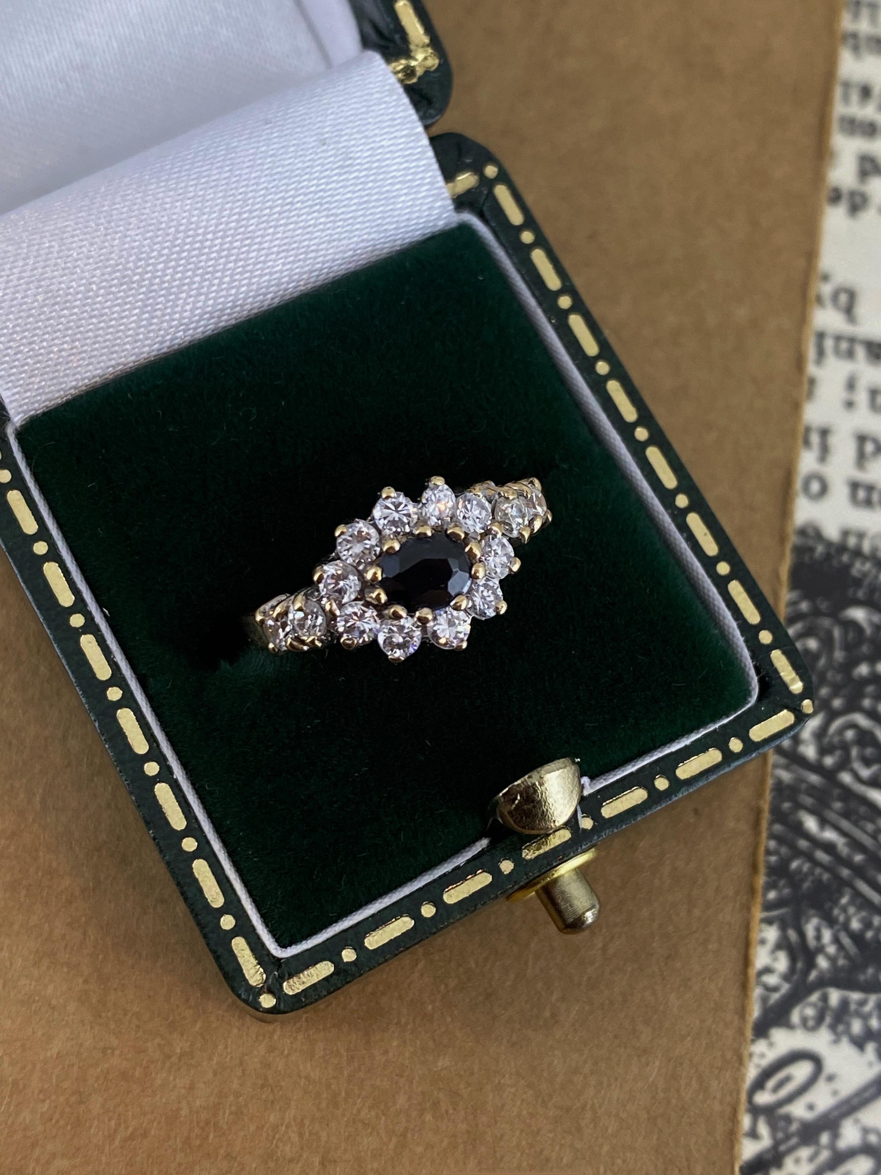 Mit wunderschönem Blumenmotiv, 
dieser Cluster-Ring ist exquisit gearbeitet
aus 9K Gelbgold, mit einem Cluster aus Edelsteinen 

In der Mitte mit einem ovalen blauen Natursaphir besetzt
von wunderschöner mitternachtsblauer Farbe, ca.