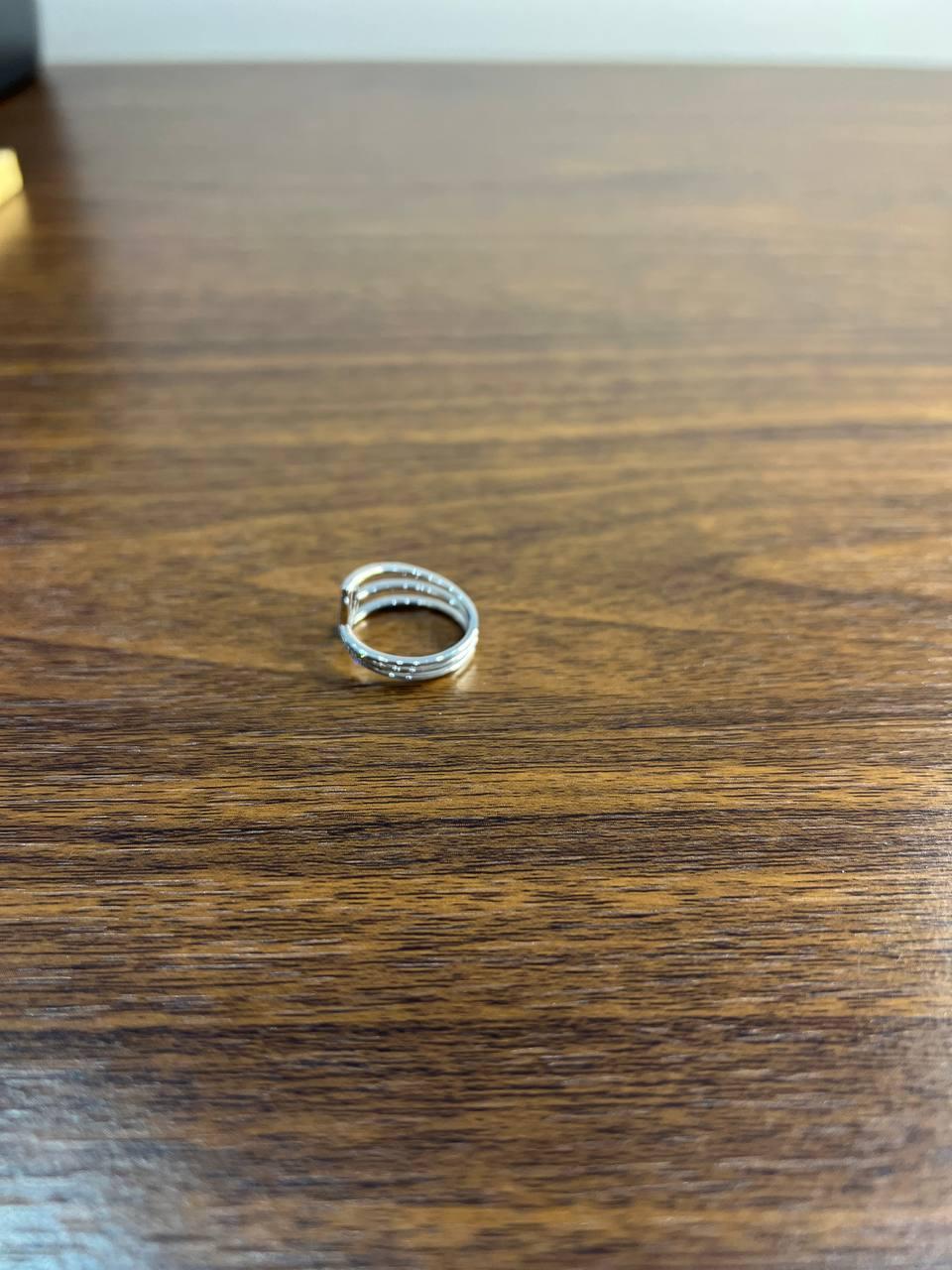 This contemporary ring features a sleek, open design with a geometric motif. The band is crafted in a polished 14K White Gold, with delicate lines forming a subtle, modern pattern. The open-ended style allows for style, adding versatility to its