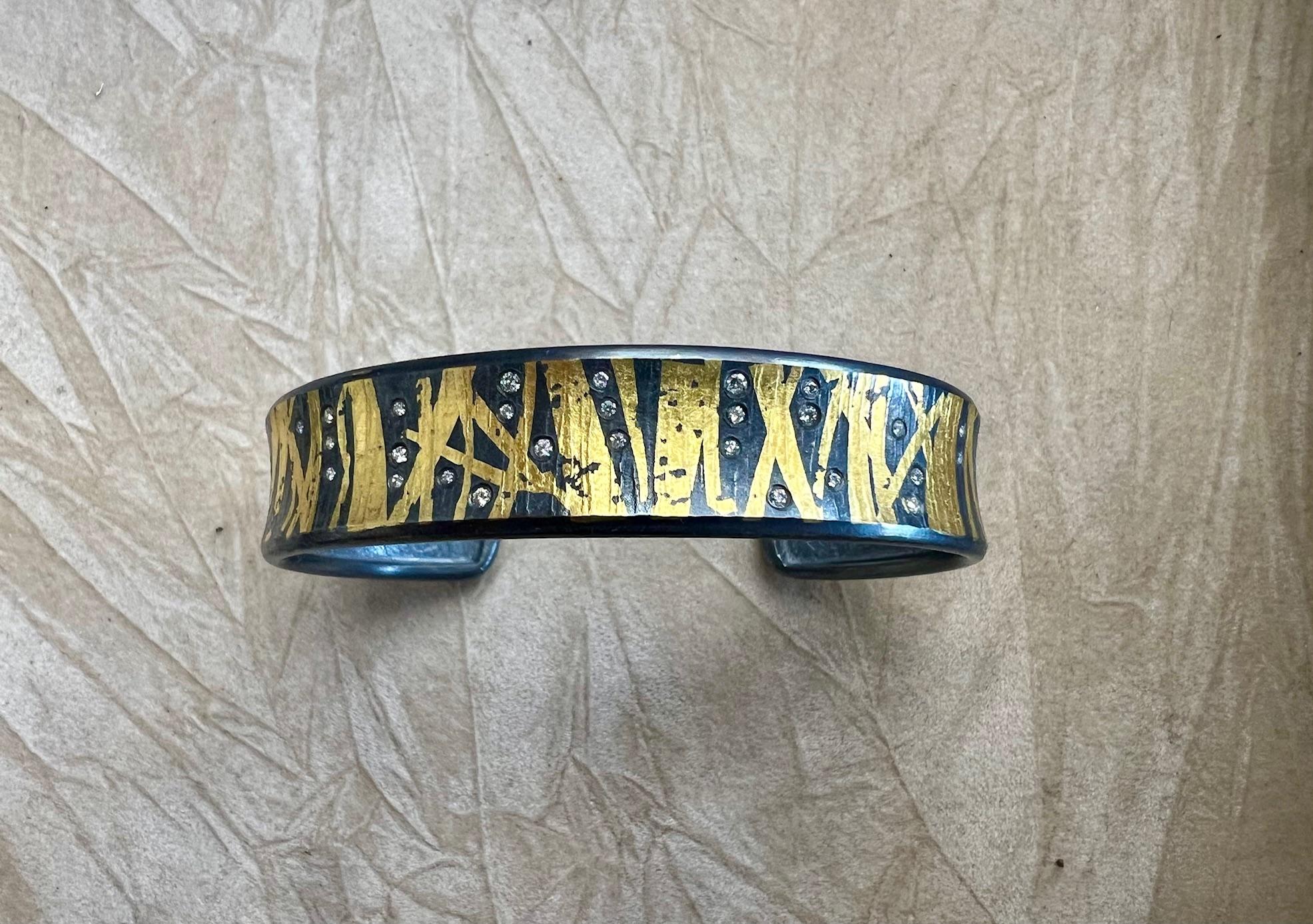 White Brilliant Cut Diamond And 24K Keum-boo Gold Leaf Cuff Bracelet.

Hand forged one-of-a-kind by Jared Porter Studio out of Colorado.

Sterling Silver with a Patina (oxidized) finish.

Note: Each bracelet is one-of-a-kind and diamond and gold