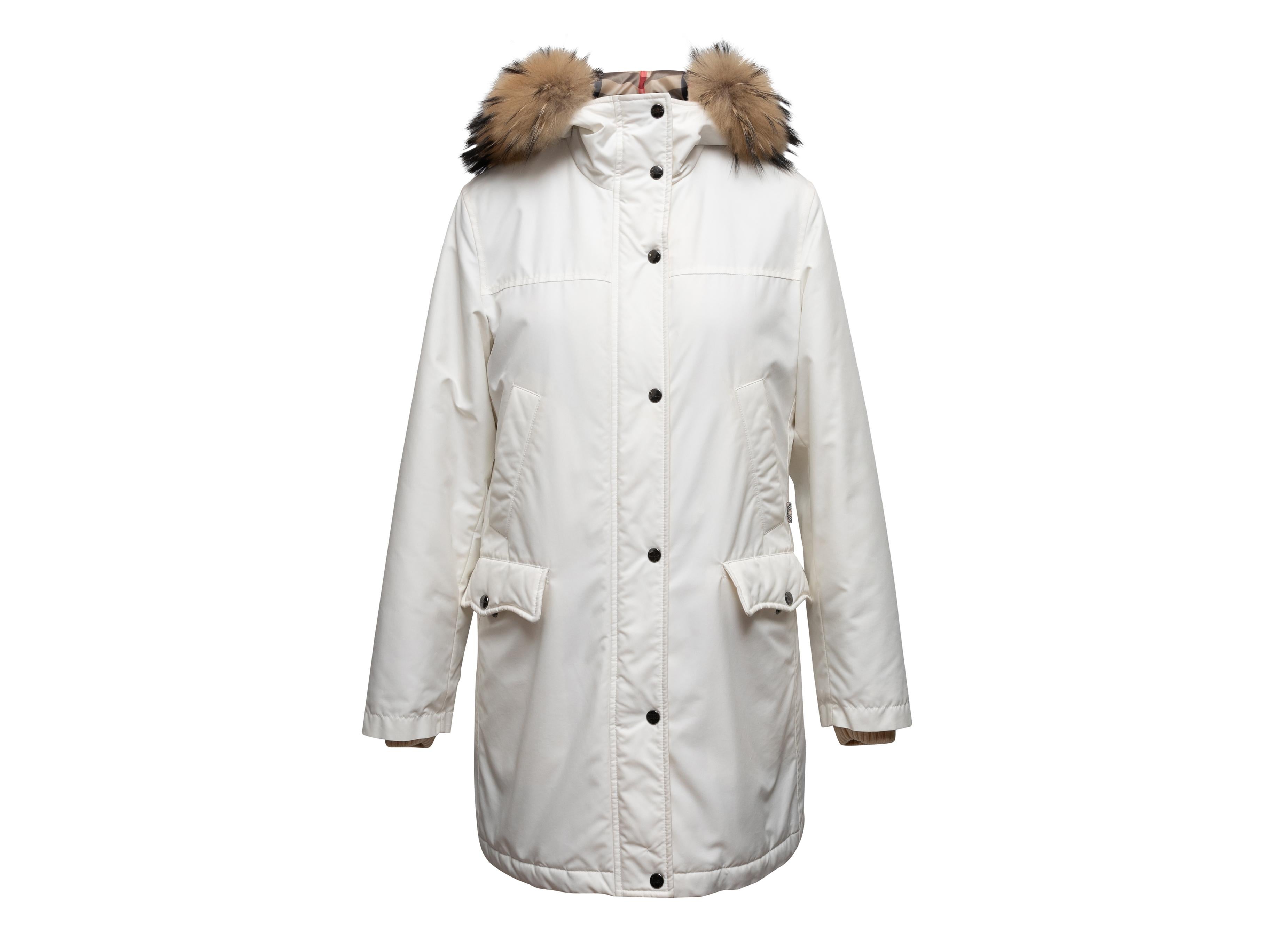 Cappotto bianco con cappuccio bordato di pelliccia di Burberry. Quattro tasche sui fianchi. Chiusura con zip e bottoni automatici sul davanti. Seno 34