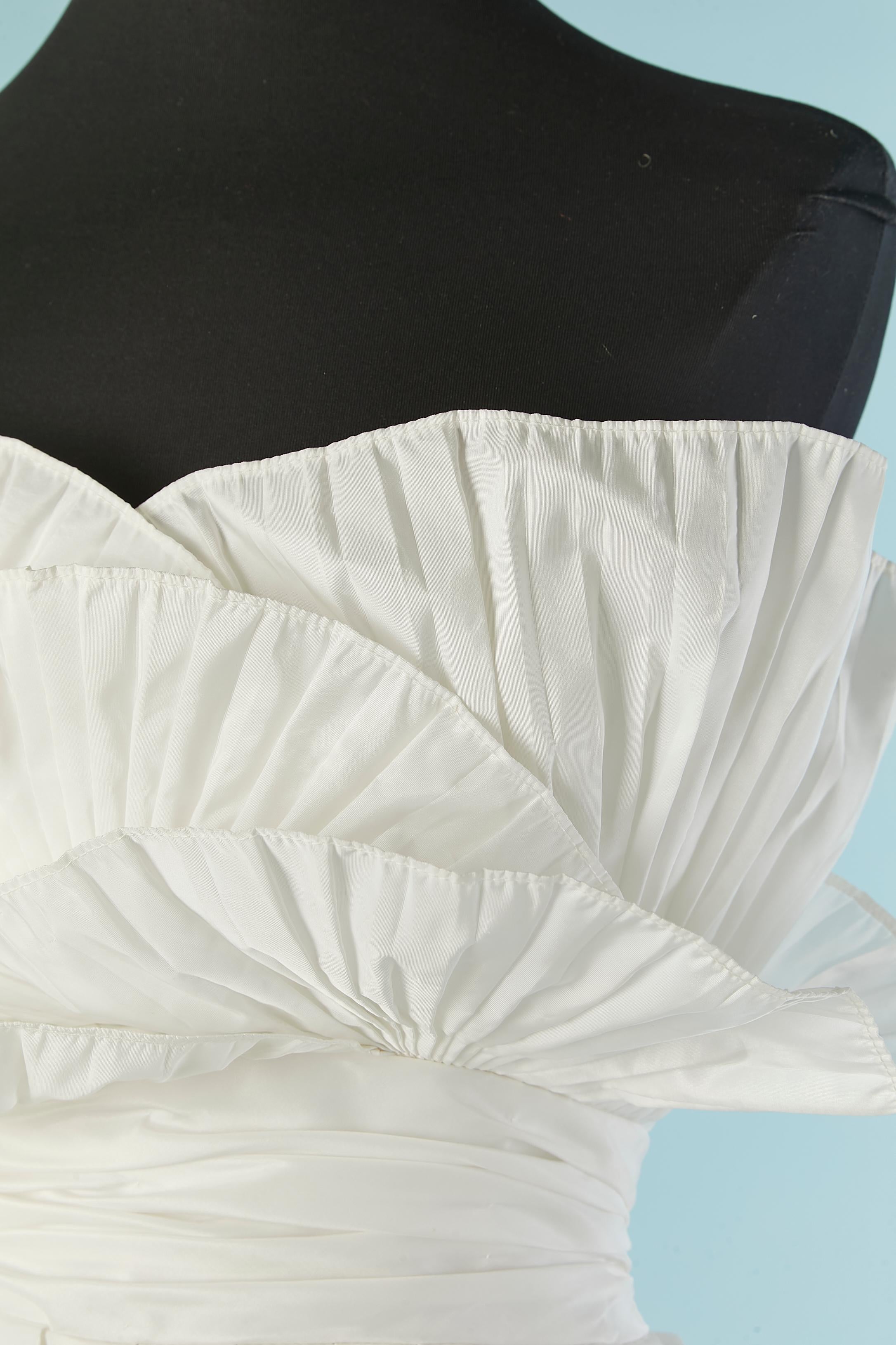 White bustier evening dress or wedding dress with pleated bustier. No fabric tag composition but the main fabric ois probably rayon and the lining is probably acetate. Stiff tulle petticoat. 
Zip closure middle back.
SIZE S 