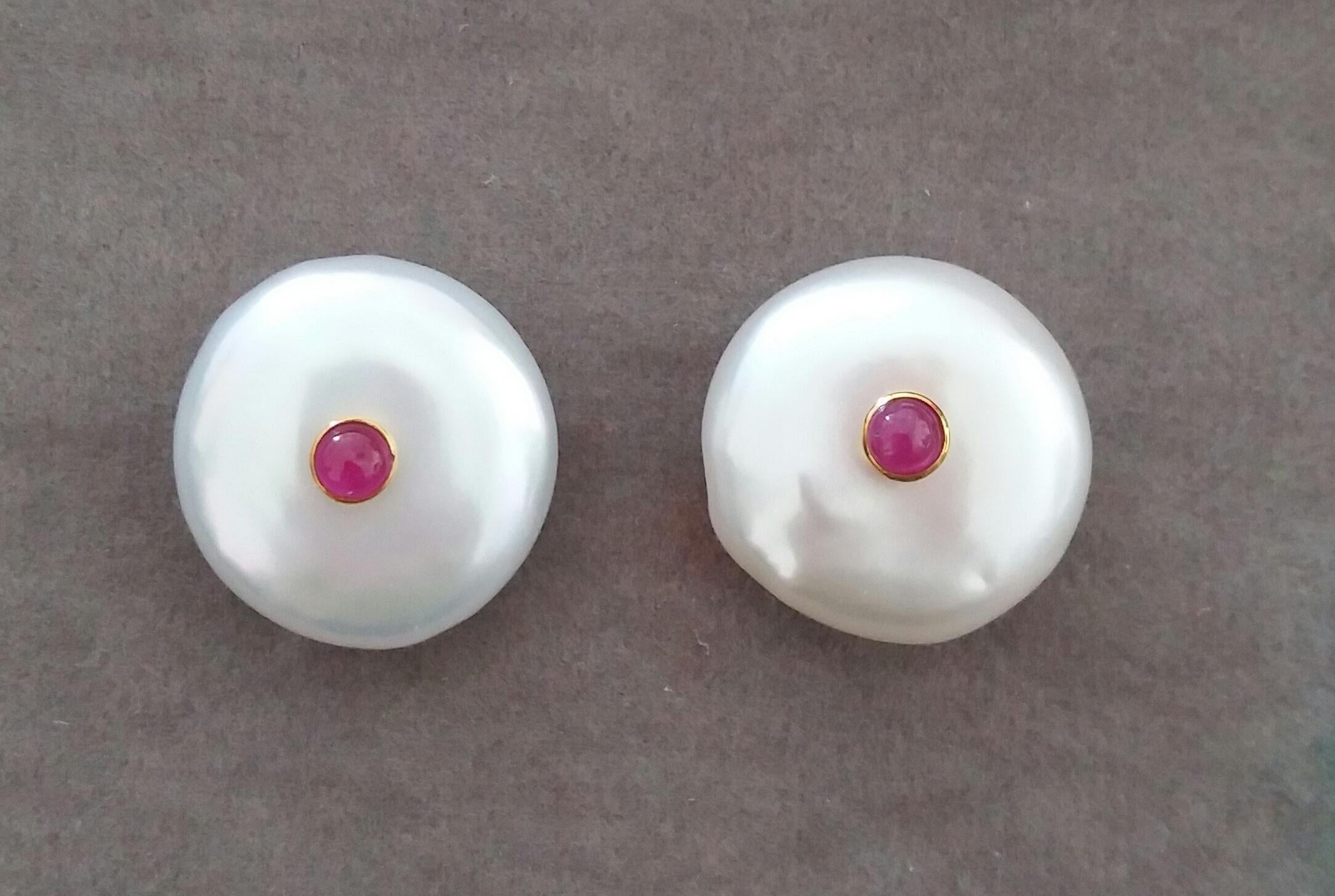 Simple and elegant earrings consisting in 2  Button Shape white color and high luster Baroque Pearls measuring about 17 mm in diameter with in the center 2 small round Ruby cabs set in 14 kt yellow gold.These Pearls are also available with small