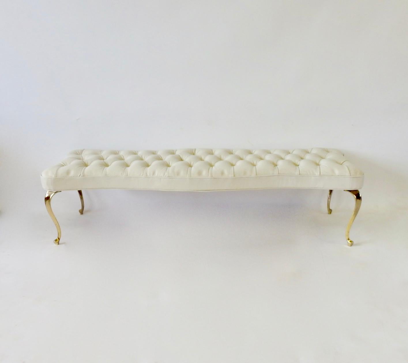 Hollywood Regency bench covered in supple leather like white Naugahyde. Legs are brass plated.