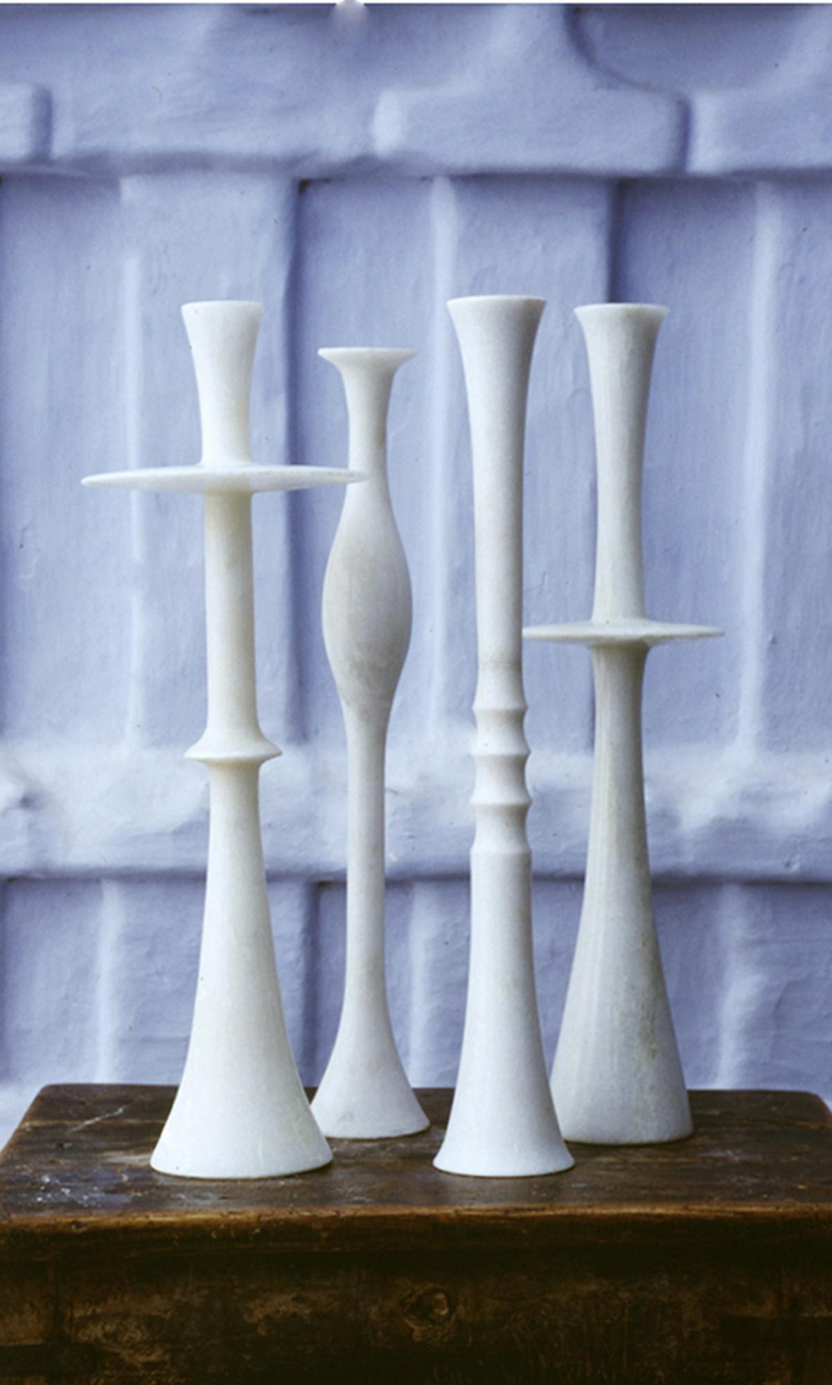 Paul Mathieu designed these elegant white candle holders in marble for Stephanie Odegard Co. Ltd. 
Solid pieces of marble are turned to create these delicate designs. The marble is hand-carved to make these marble candle sticks, namely Ove, Flute,