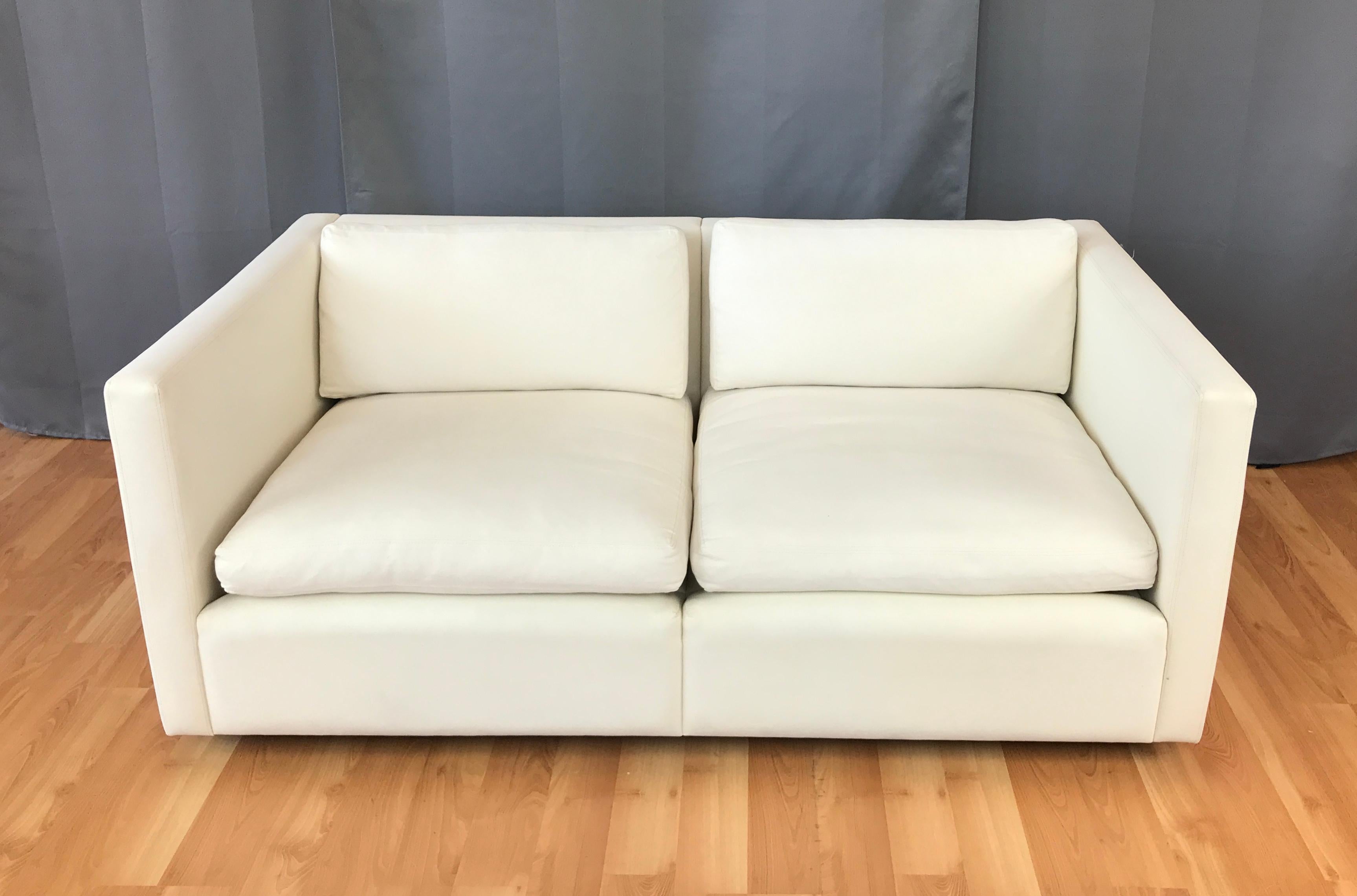 A crisply styled off-white model 1052C settee or loveseat designed by Charles Pfister for Knoll in 1971, and produced around 2009.

Perfectly proportioned and quite comfortable, with a very clean, contemporary aesthetic. Original Knoll cotton canvas