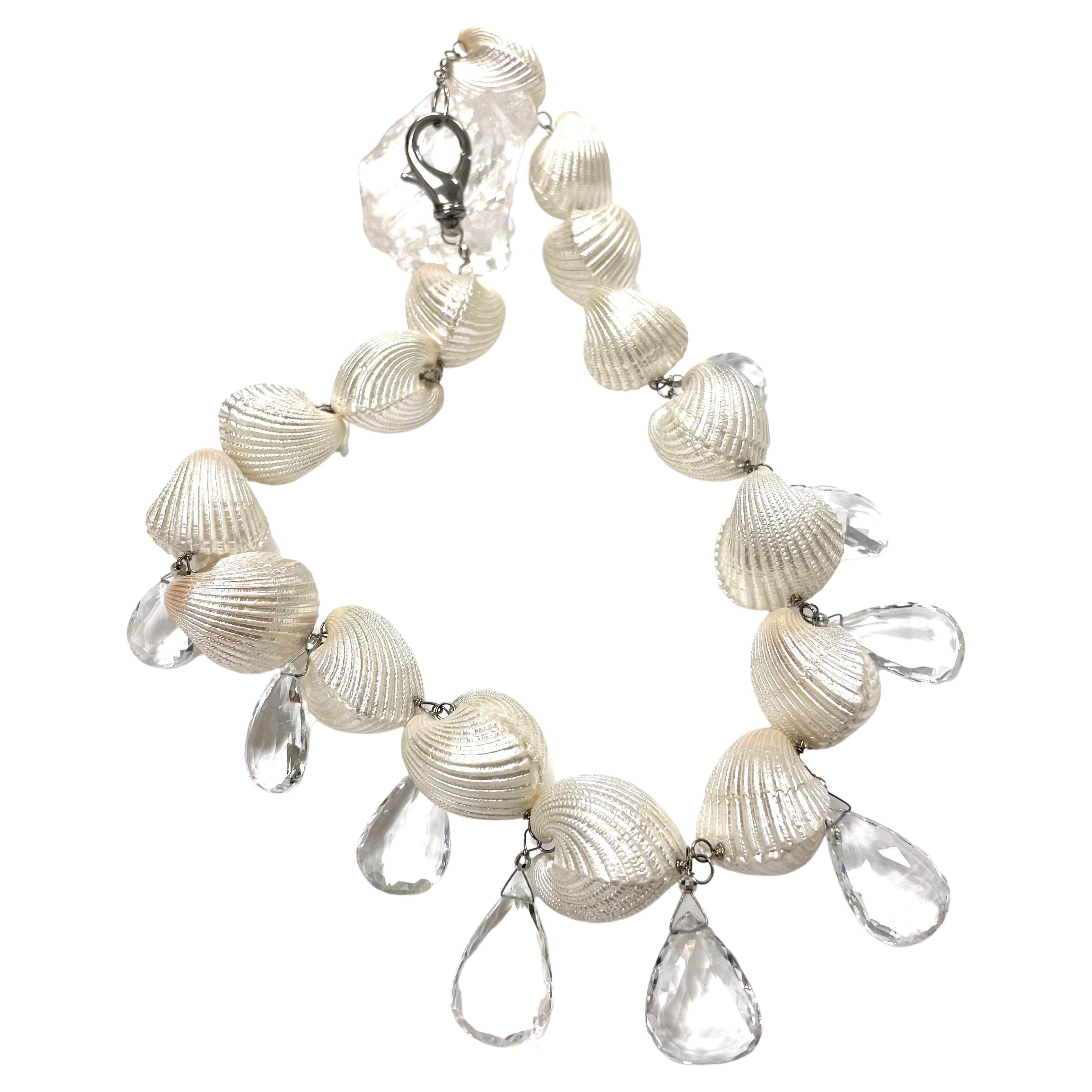 Description
This unique, striking and delightful statement necklace expresses your own personal summer flair. An uncommon mix of beautifully lacquered Caribbean Ark shells with large, elegant and rare white topaz drops, makes this necklace a must
