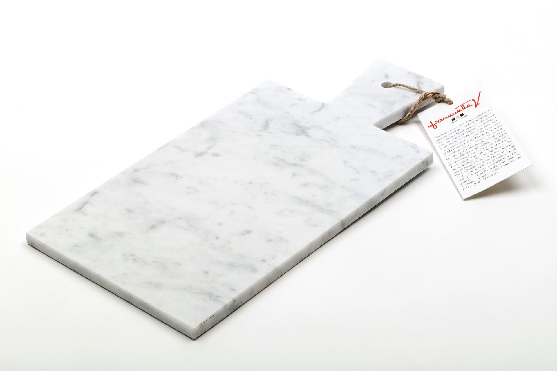 White Carrara marble cutting board and hole on the handle to hang it. Each piece is in a way unique (every marble block is different in veins and shades) and handmade by Italian artisans specialized over generations in processing marble. Slight