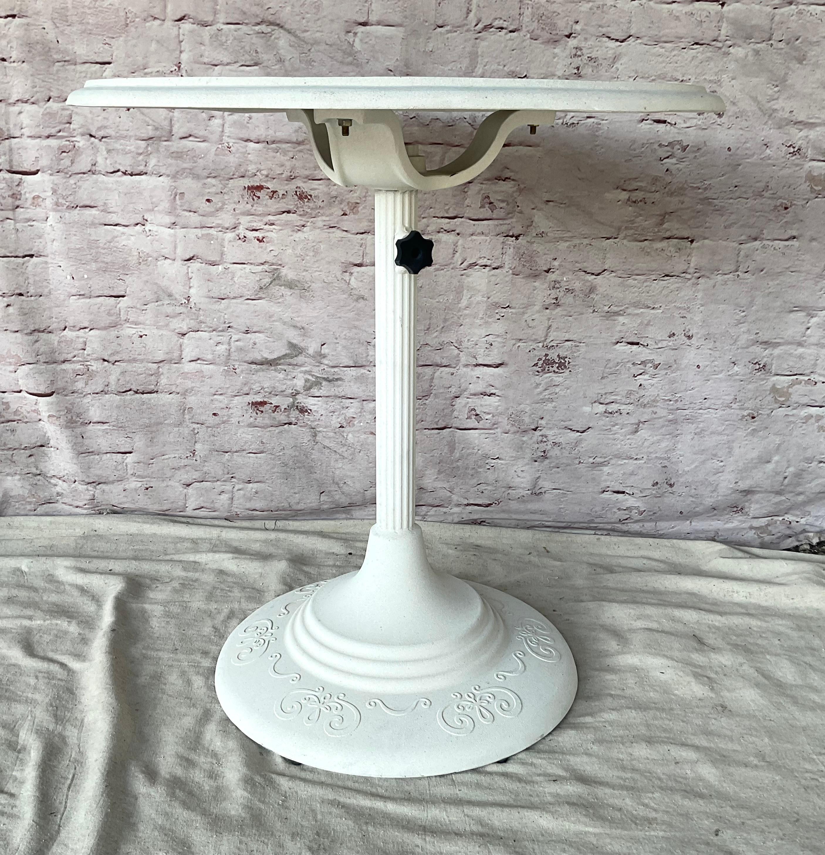 Tavolo rotondo da patio in alluminio fuso del 20° secolo, di colore bianco. Il tavolo è di ottima fattura e presenta un classico design floreale e a volute di ispirazione vittoriana che evoca il fascino dei tradizionali mobili in ferro battuto, ma