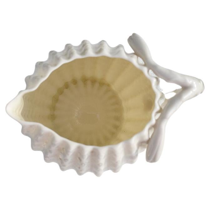 Un petit pichet crémier en céramique blanche à motif de cactus. Cette pièce sera un excellent complément à toute table de petit-déjeuner. L'extérieur a une texture en pointe et ressemble à un cactus avec une poignée en faux bois. 

Dimensions