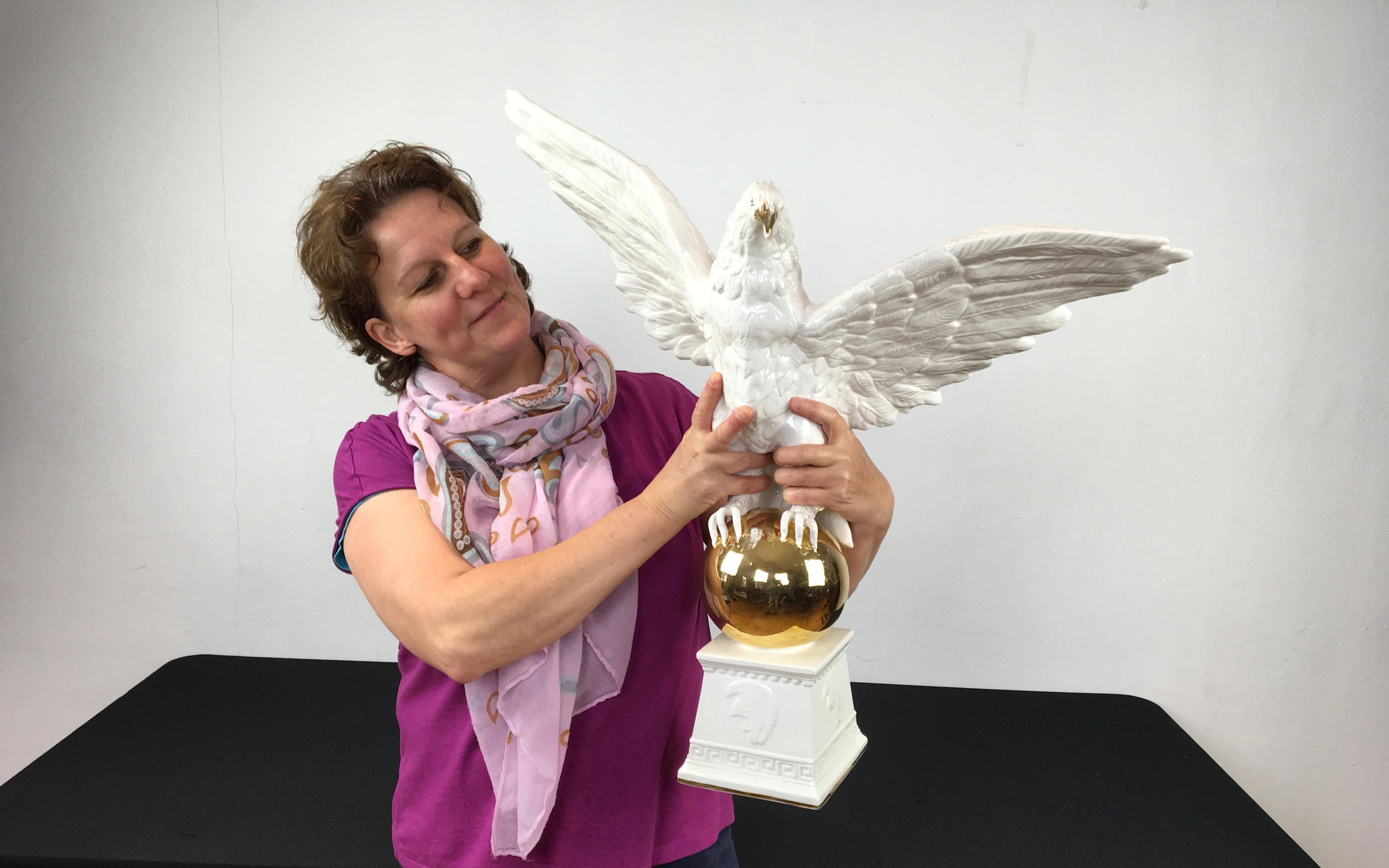 1970s Italian white ceramic Eagle sculpture. 
A large eagle sculpture with his wings spread wide open. 
This white eagle statue - eagle sculpture or Roman Eagle was probably made by Bassano Italy.  It has hand-painted golden details, detailed