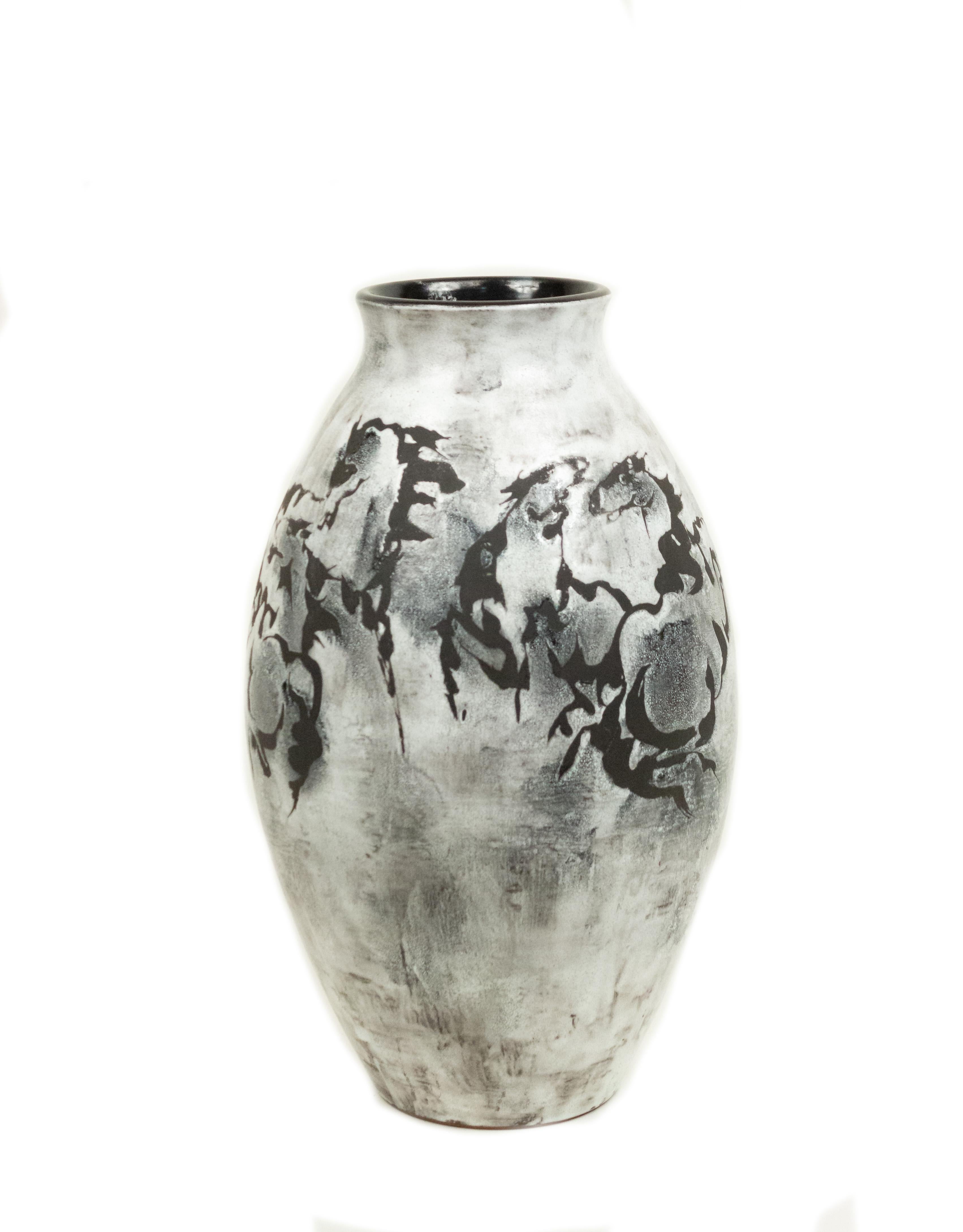White and black vase with running horse design.
 